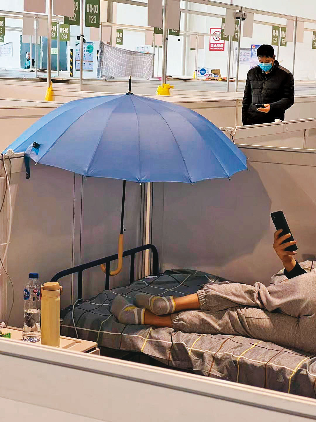 方艙醫院內燈火日夜通明,民眾以雨傘擋光。(陳小姐提供)
