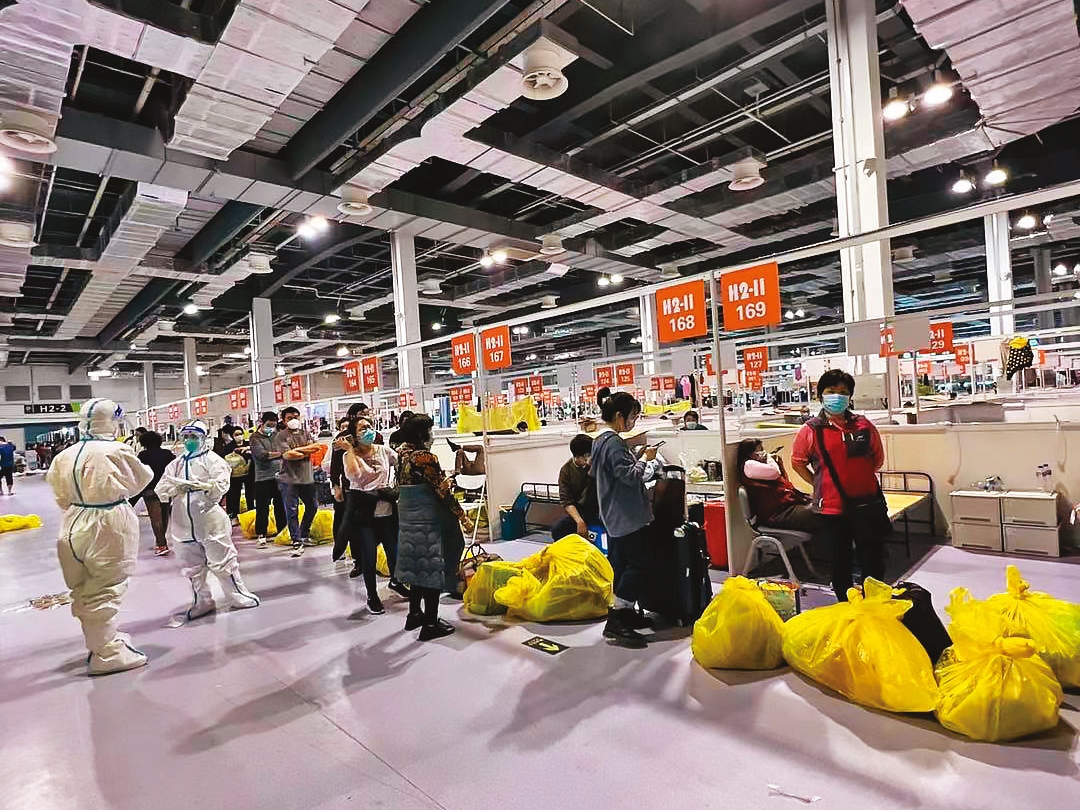 方艙醫院以簡單隔板和行軍床構成，輕症和無症狀民眾報到後排隊領物資準備入院。（陳小姐提供）