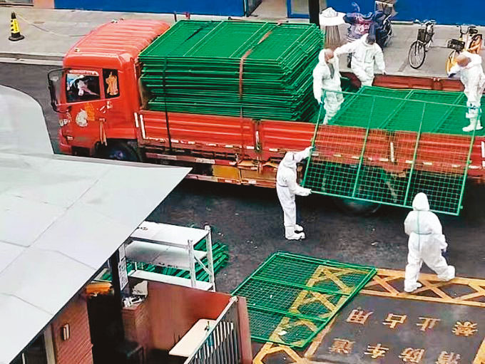 中國政府運來大量鐵網架封鎖小區。（翻攝自推特）