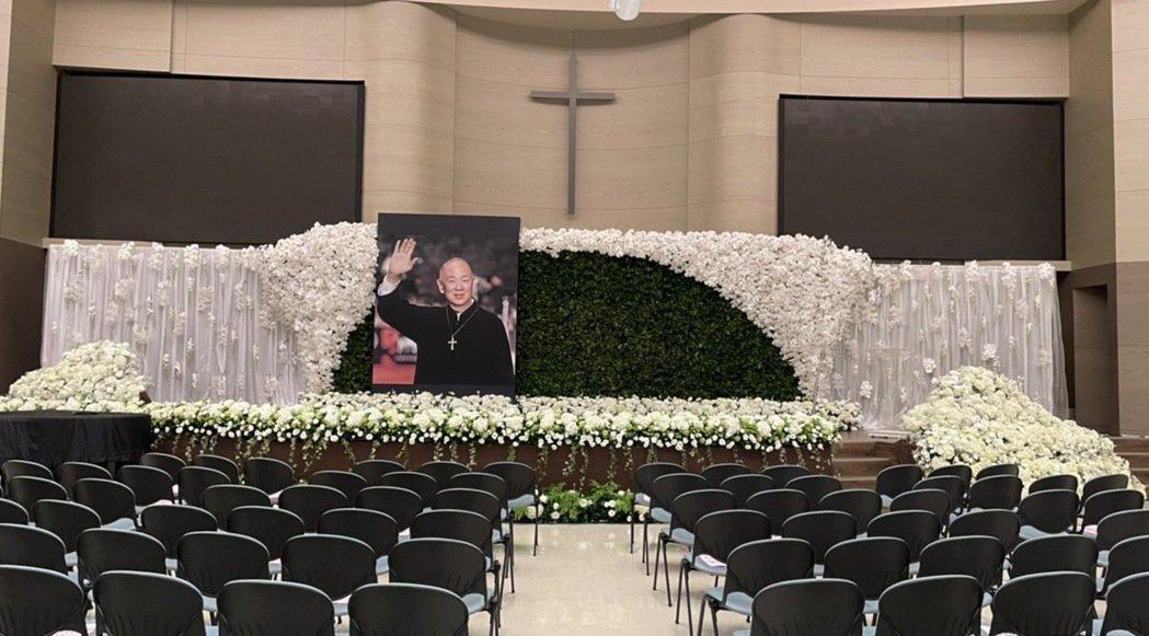 追思禮拜會場以白色鮮花布置，遺照則選用了王羽2011年入圍金馬男配獎，在紅毯揮手的照片。（家屬提供）
