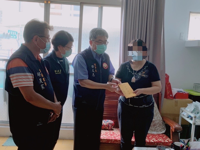 嘉邑行善團理事長徐文志（右二）致送扶助救助金給新住民金蘭（右一）。（移民署提供）