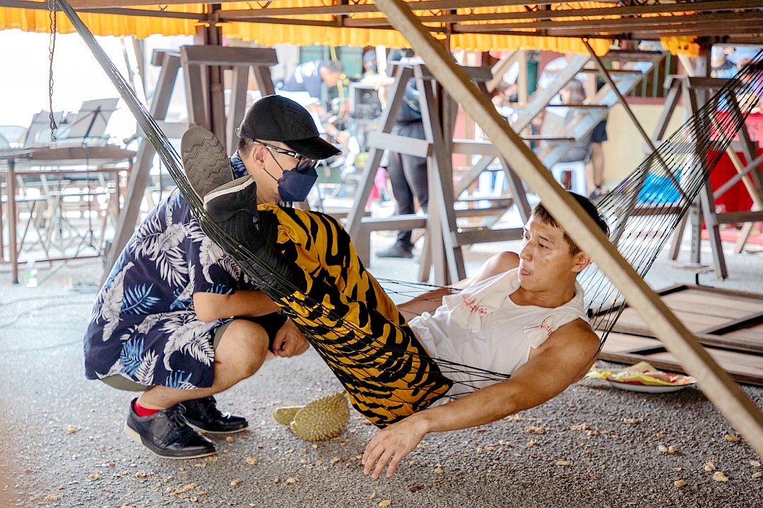 導演張吉安指導鄭人碩如何大啖榴槤。（海鵬影業提供）