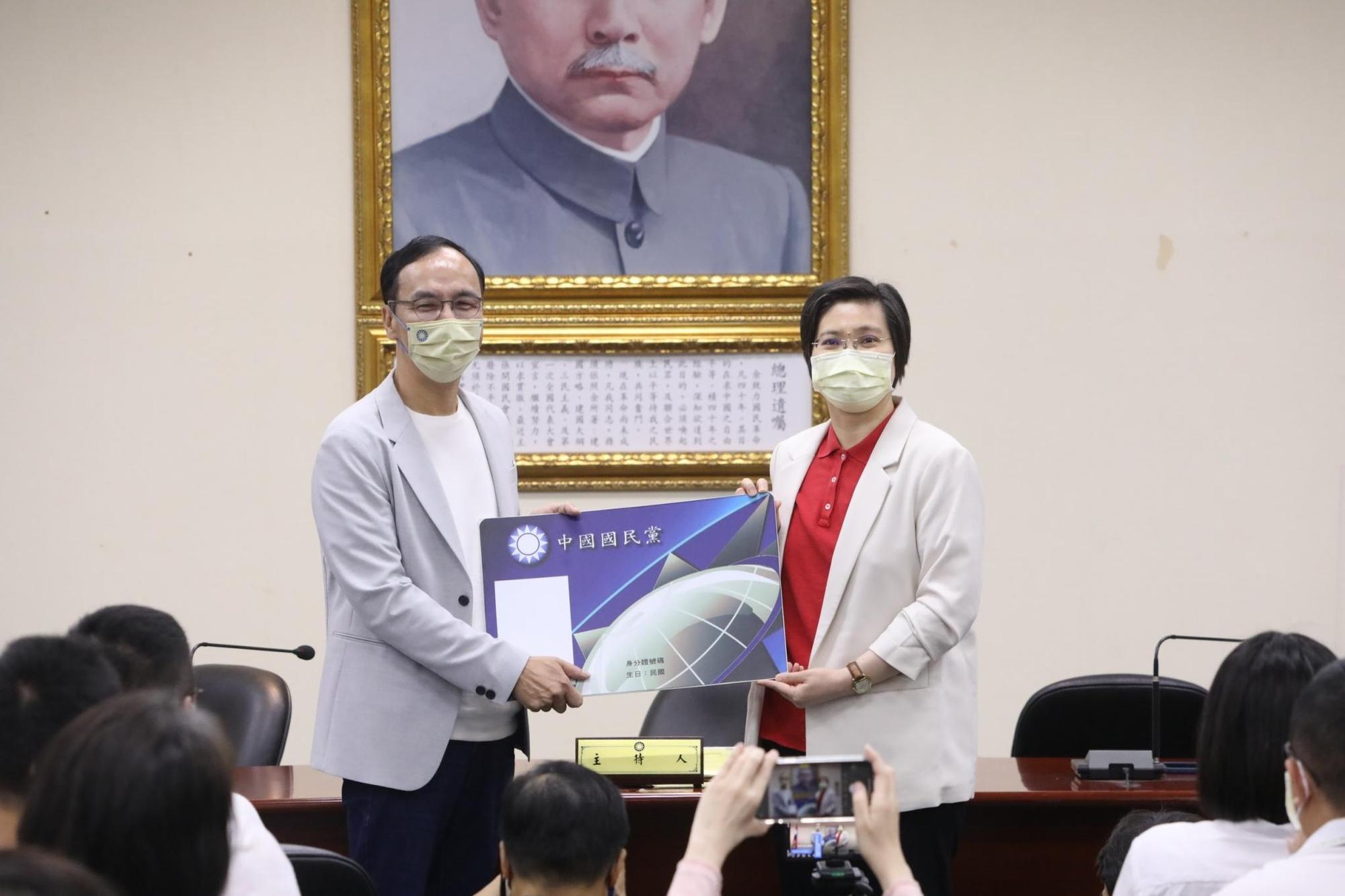 妙天大弟子徐欣瑩（右）重返國民黨，主席朱立倫親自迎接並頒發大幅黨證。（國民黨提供）