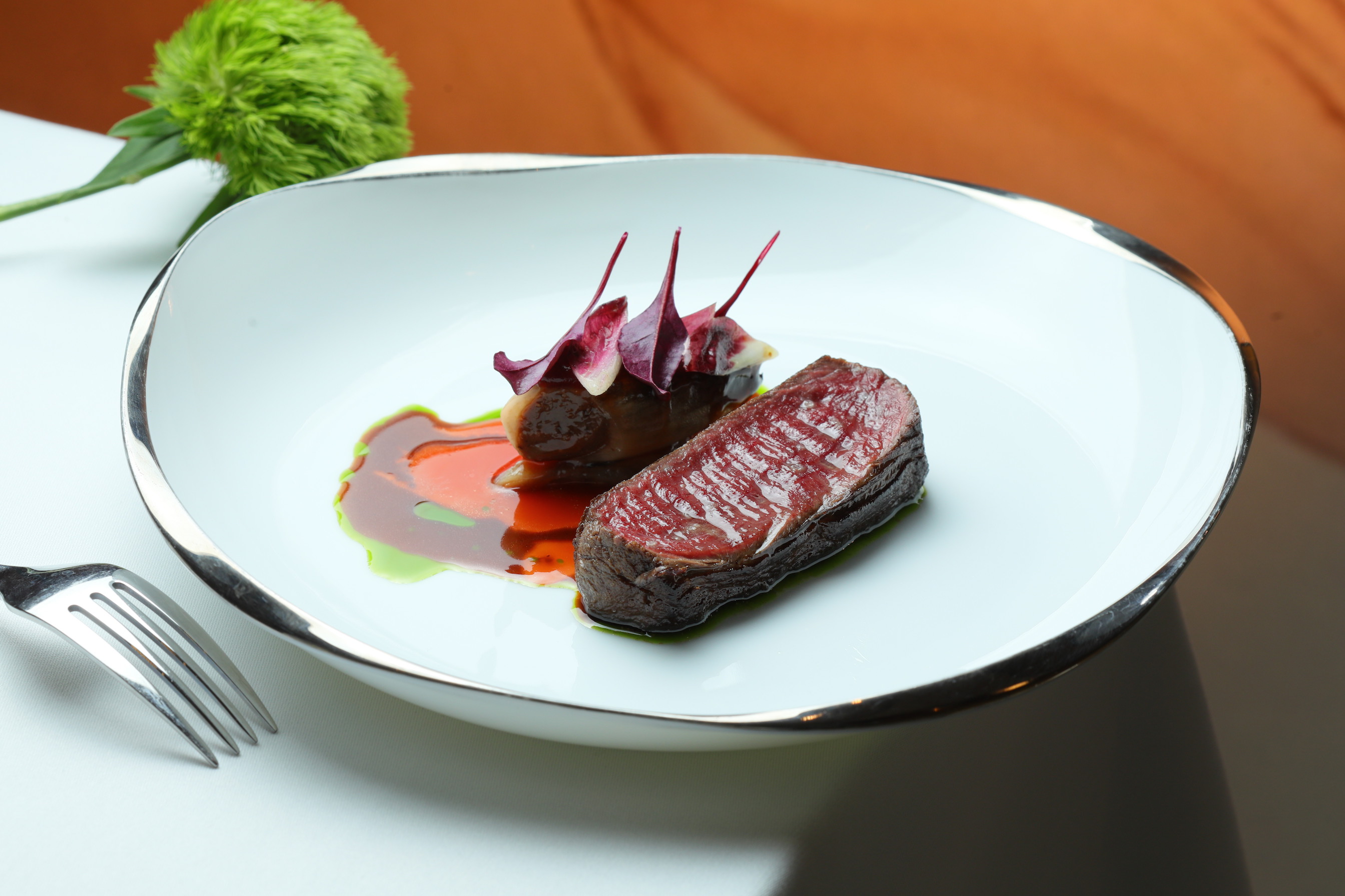 「柴燒鹿肉 菊苣 洛神」以黑醋栗、龍蒿油及蔬菜高湯作為搭佐的三色醬汁，皮脆肉甜。