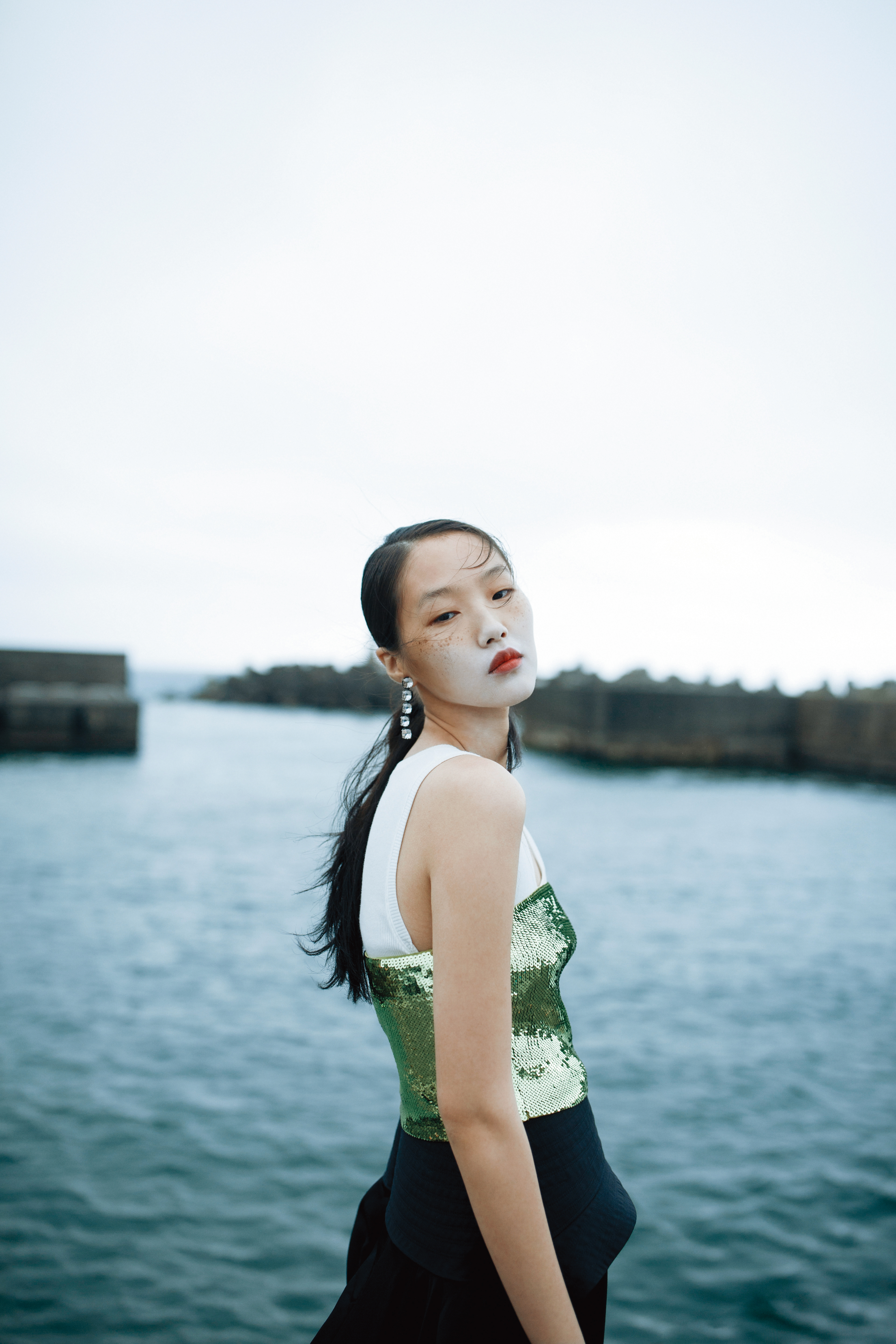 白色Anagram背心上衣 NT$12,000 by LOEWE；綠色亮片平口背心 NT$43,000 by LOEWE；黑色荷葉邊長褲 NT$79,000 by LOEWE；Harmonia水滴型耳環 NT$5,450 by SWAROVSKI。