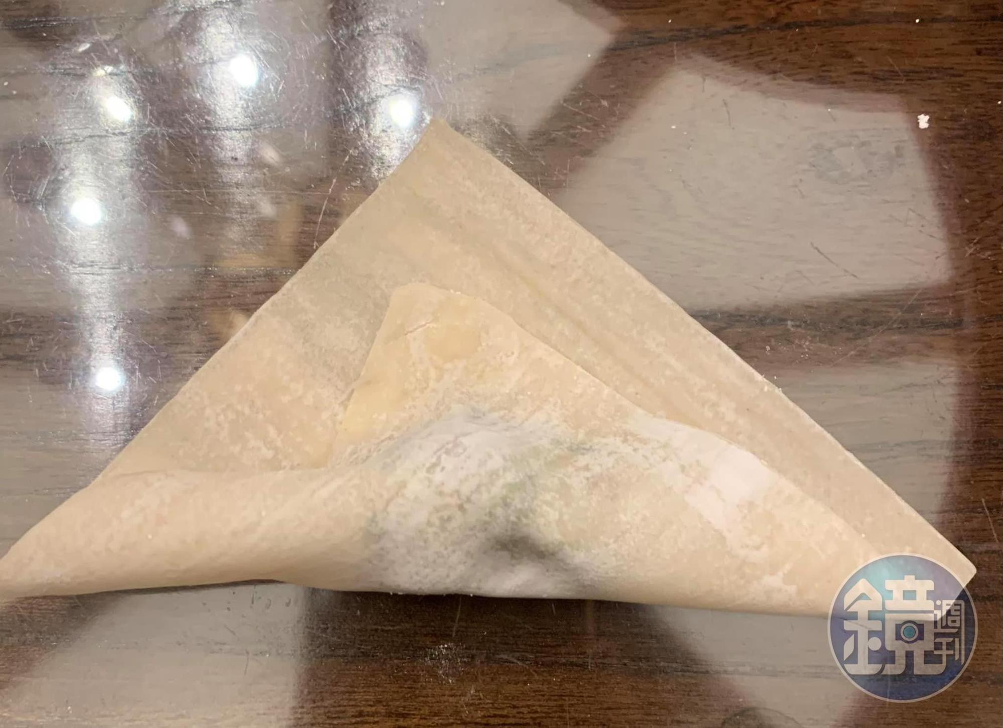 包薺菜餛飩步驟二：一角沾水對折輕壓。