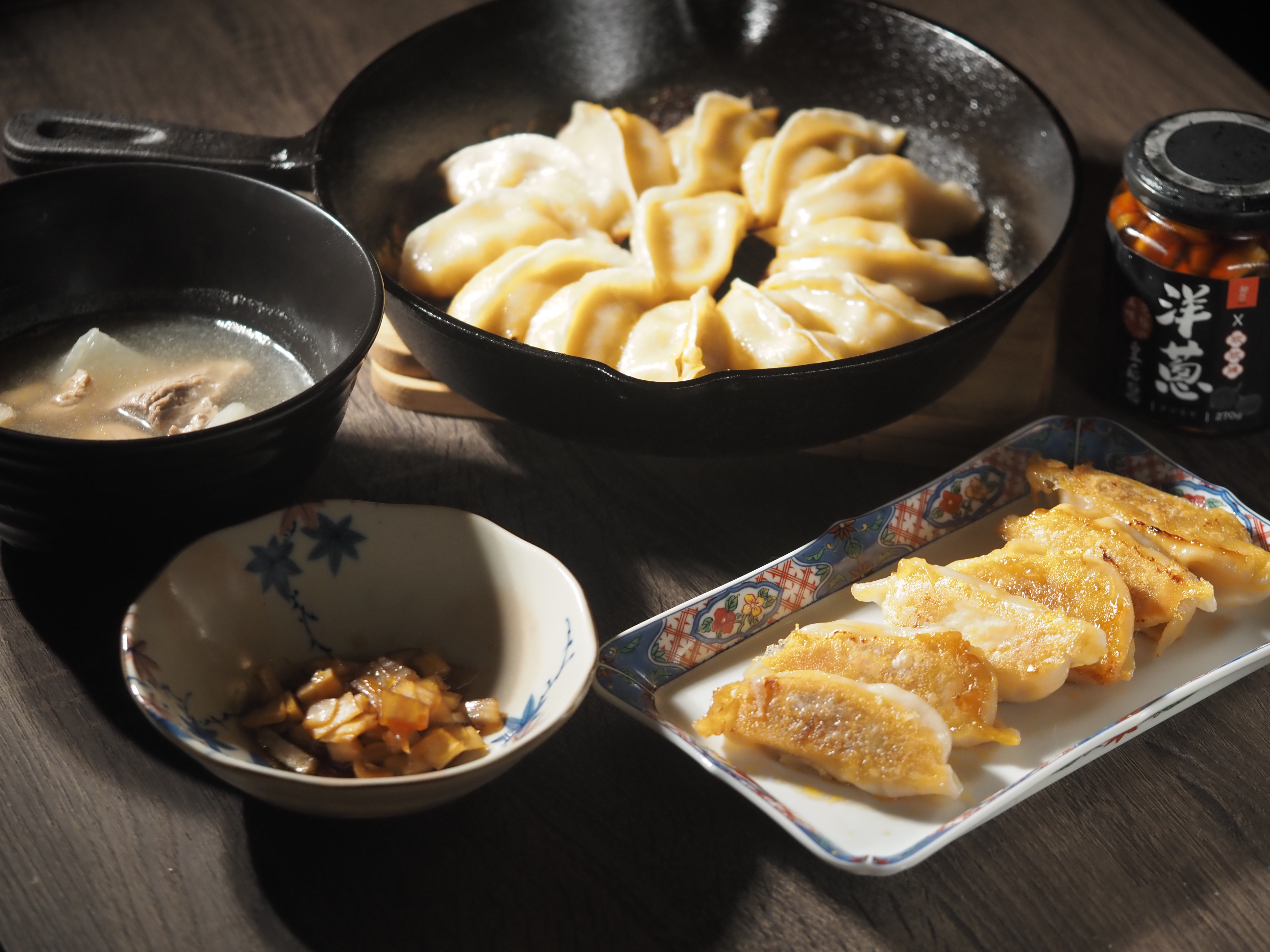 「屋台椒麻煎餃」（右）香氣與辣度平衡度抓得不錯，與鮮美解辣的「鰹魚白蘿蔔湯」（左上）是絕配；「洋蔥皇后醬」（左下）則兼顧了味道與口感的層次。（煎餃與湯為防疫箱內容，洋蔥皇后醬288元／瓶）