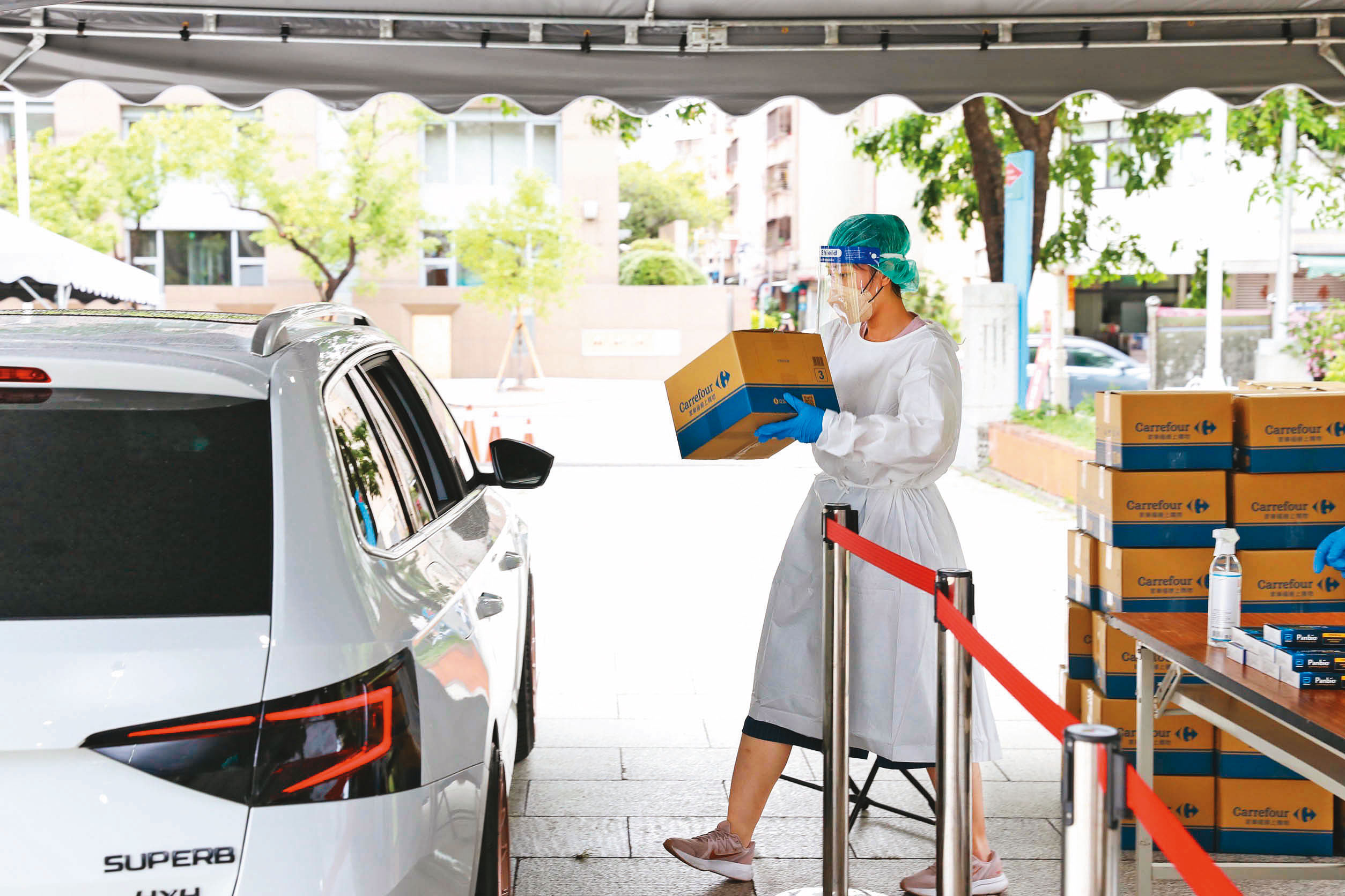 確診者關懷是這波疫情高峰的重要課題，高雄市首創「關懷包得來速」，由隔離者同住家人代領，免去民政基層人力負擔，也讓隔離者可盡快獲得快篩劑、食物等物品。