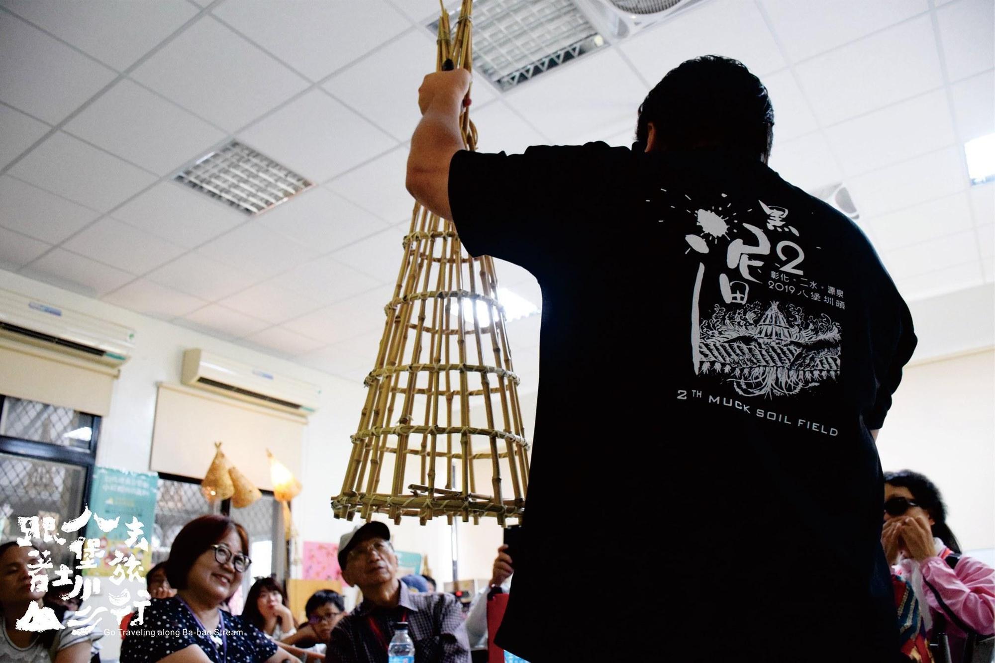 賴昭旭和在地的老師傅教旅客製作縮小版的「籠仔篙」。（源泉社區發展協會提供）