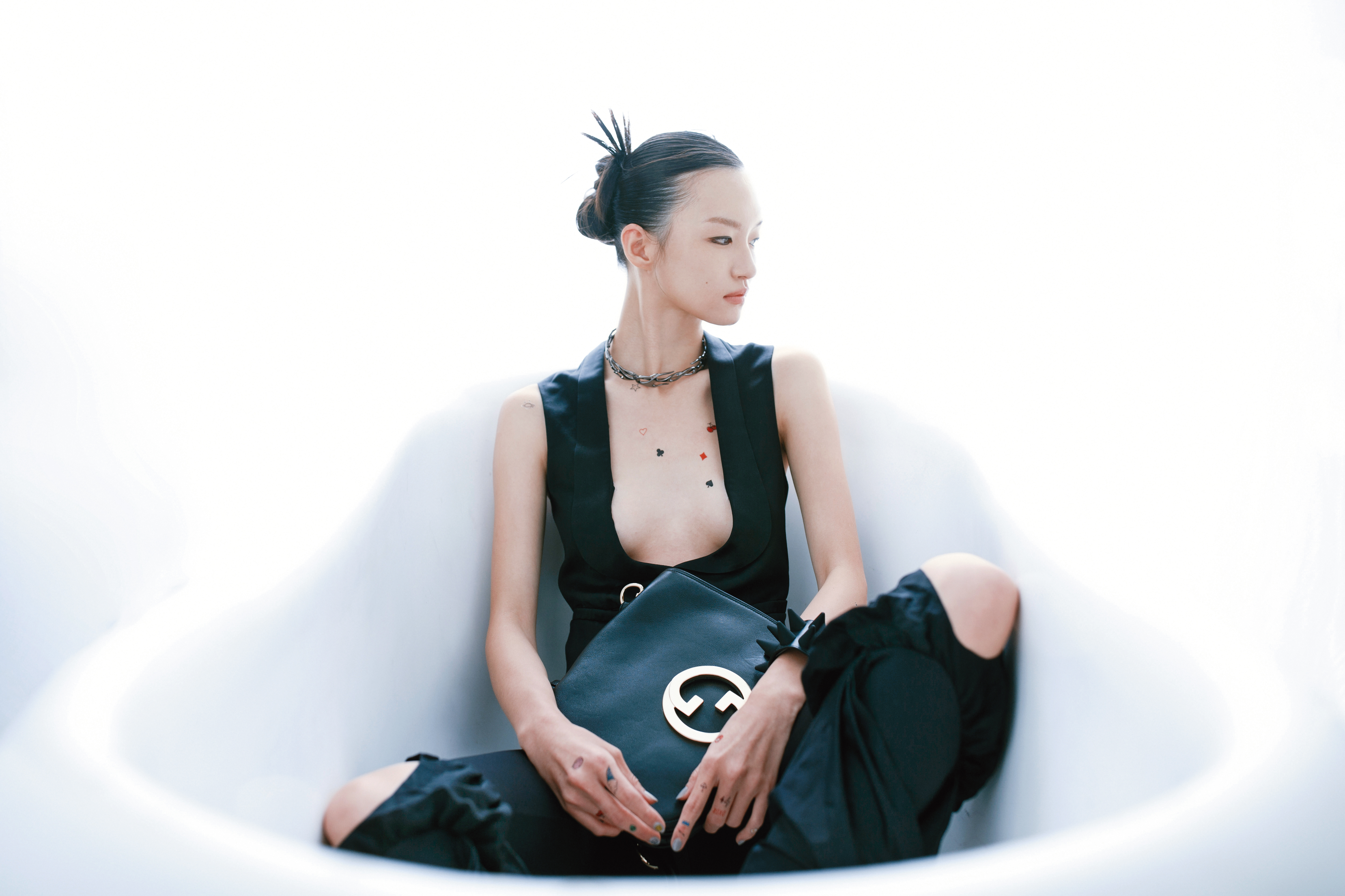 黑色馬甲背心NT$34,000 by GUCCI；黑色合身長褲NT$61,000 by LOEWE；短項鍊NT$1,499 by H&M Innovation Cherish Waste；Blondie黑色肩背包NT$113,100 by GUCCI；鉚釘手鐲 NT$1,499 by H&M Innovation Cherish Waste。