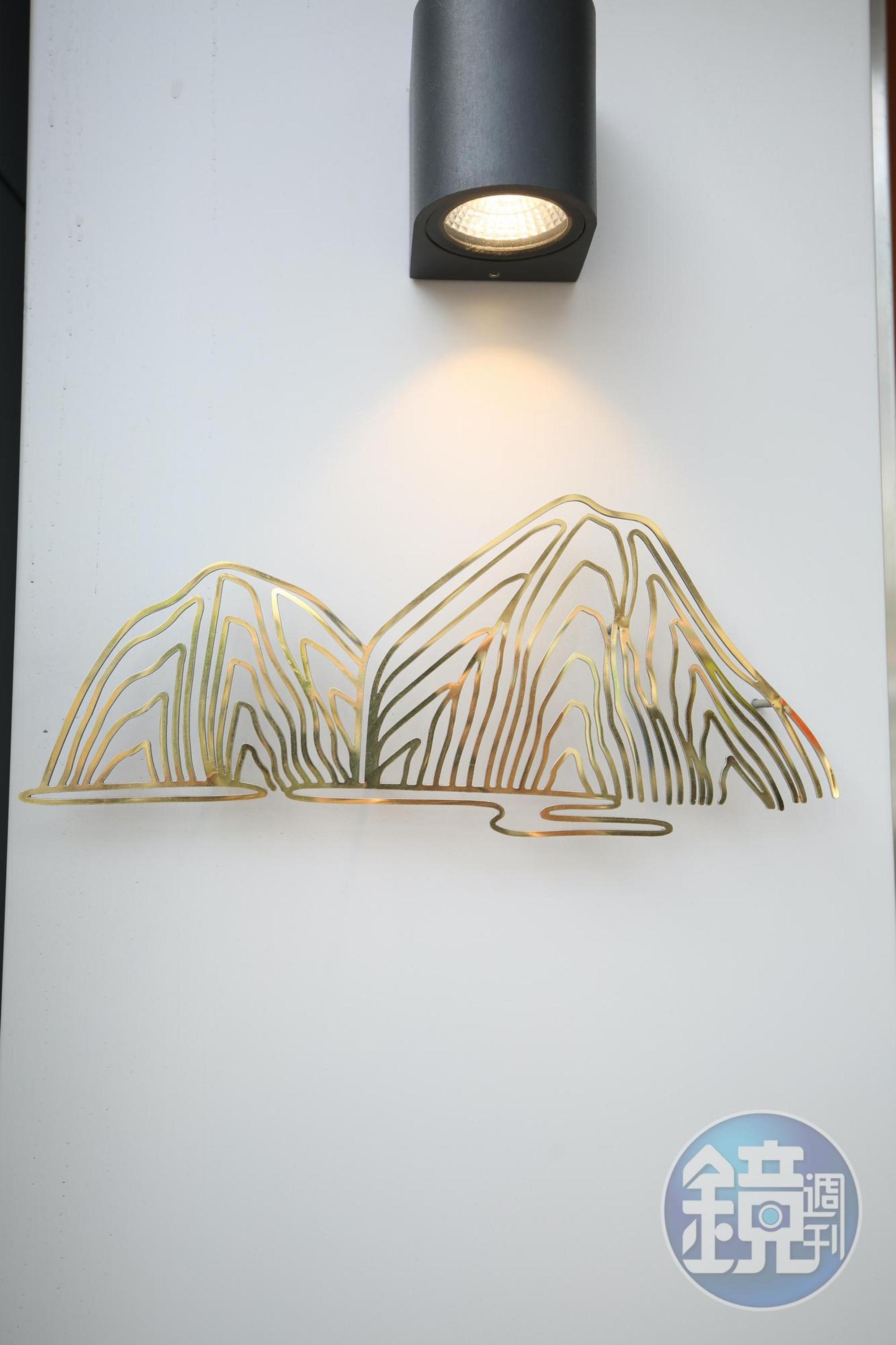 以鍍鈦打造的小籠湯包山谷logo,層疊聳立,帶有禪意。