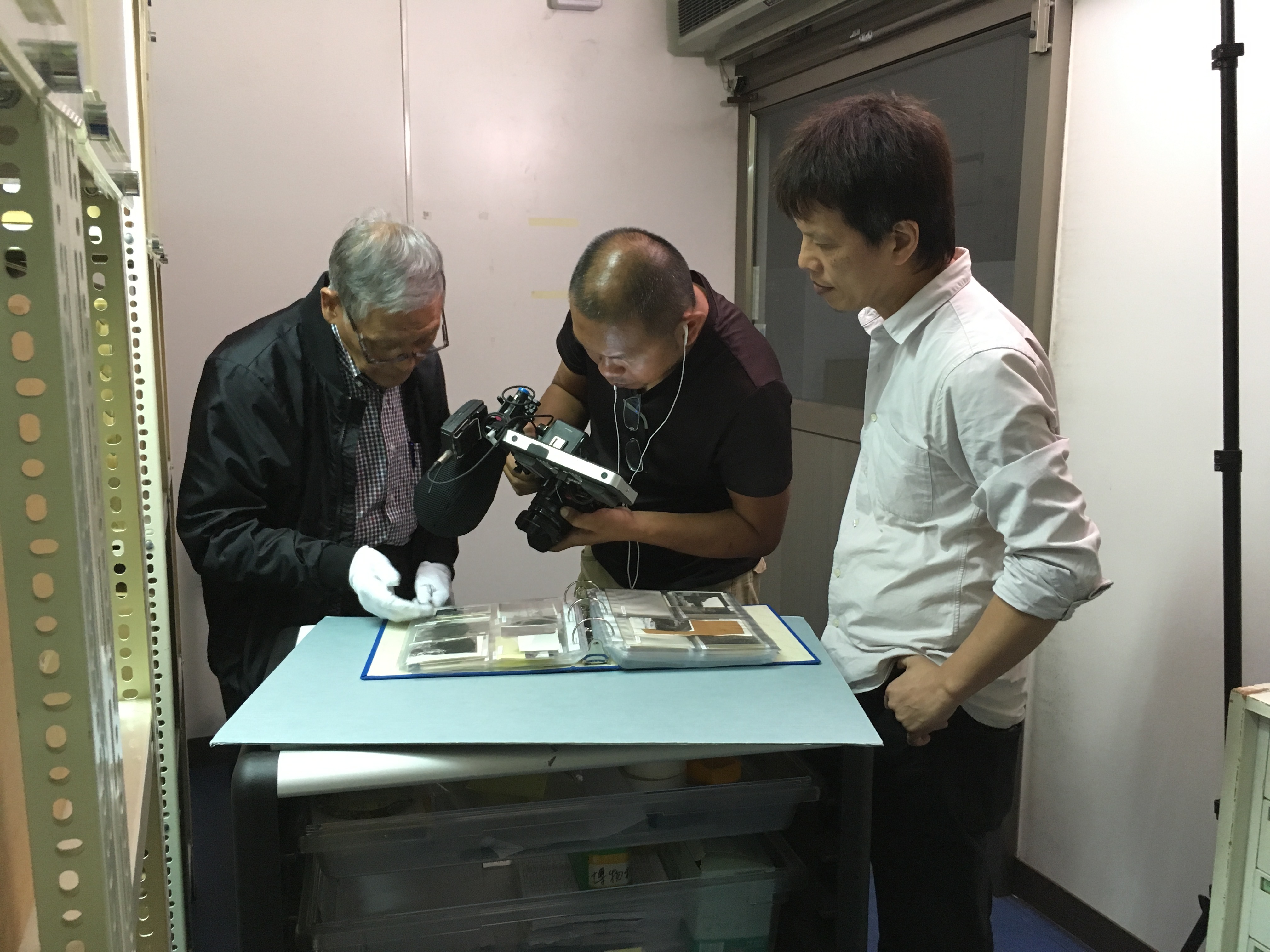 電影耗時4年半,除了訪問多位重量級影人,胡金銓也留下許多珍貴資料,石雋與導演林靖傑正仔細翻閱。(華映)