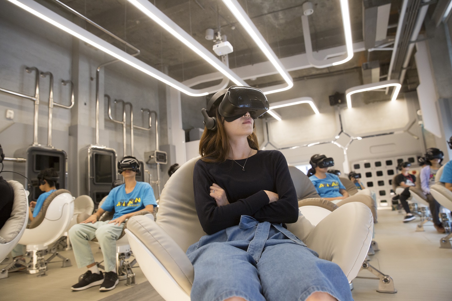 科幻風格的VR體感劇院內,觀眾可以戴上頭戴式顯示器、坐在圓弧形蛋椅上觀賞。