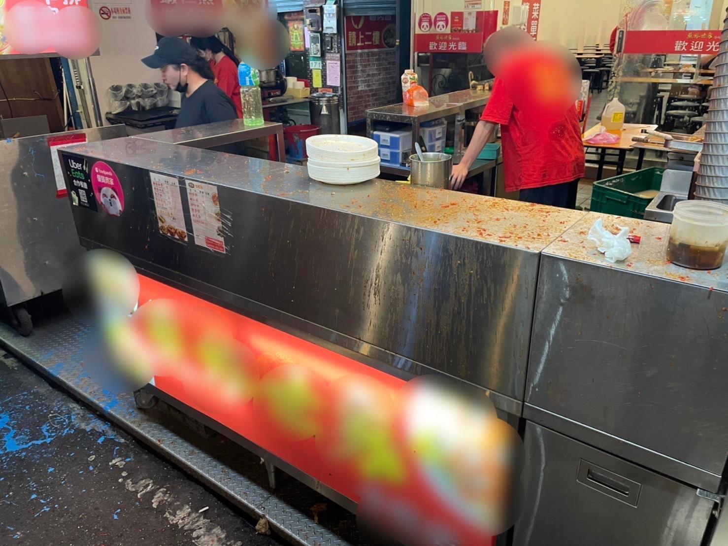店家門口遭潑漆，地面都是藍色油漆。（翻攝畫面）