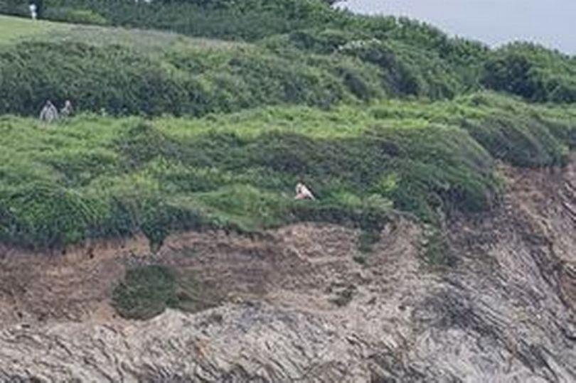英國一對情侶忘情在海岸上激戰,對面目擊的餐廳客人也樂在其中。(翻攝自推特)