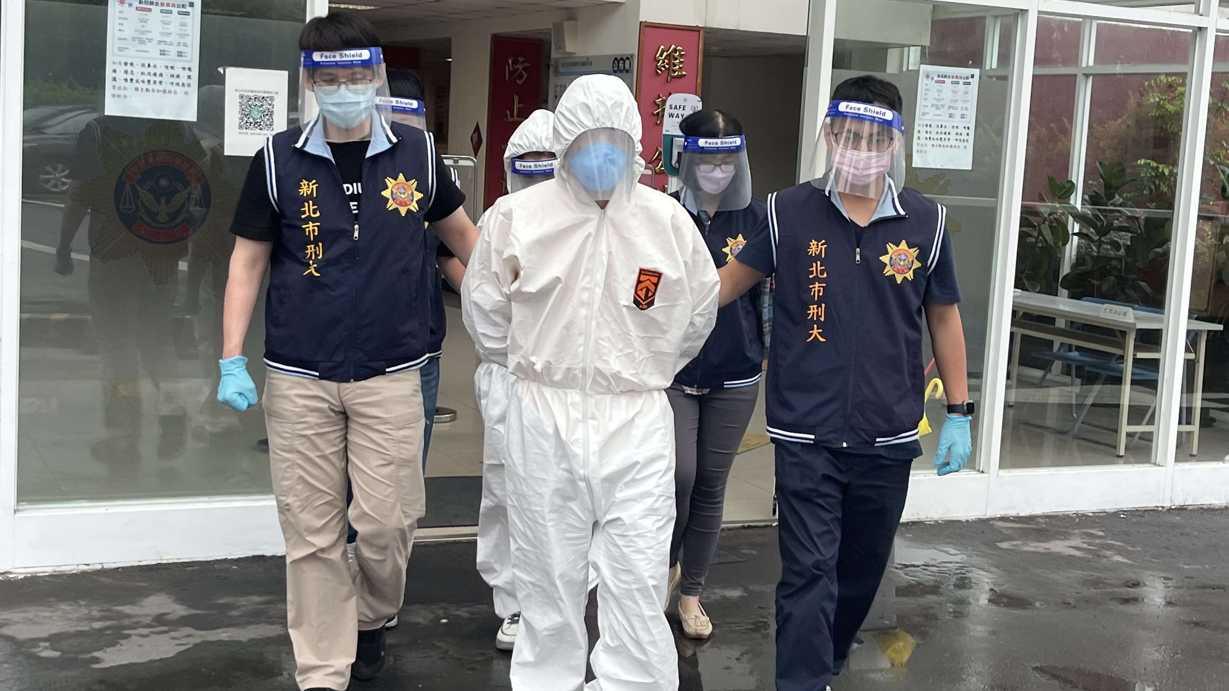 嫌犯快篩檢測後呈陽性反應,警方為2人穿上防護衣後戒護送辦。(警方提供)