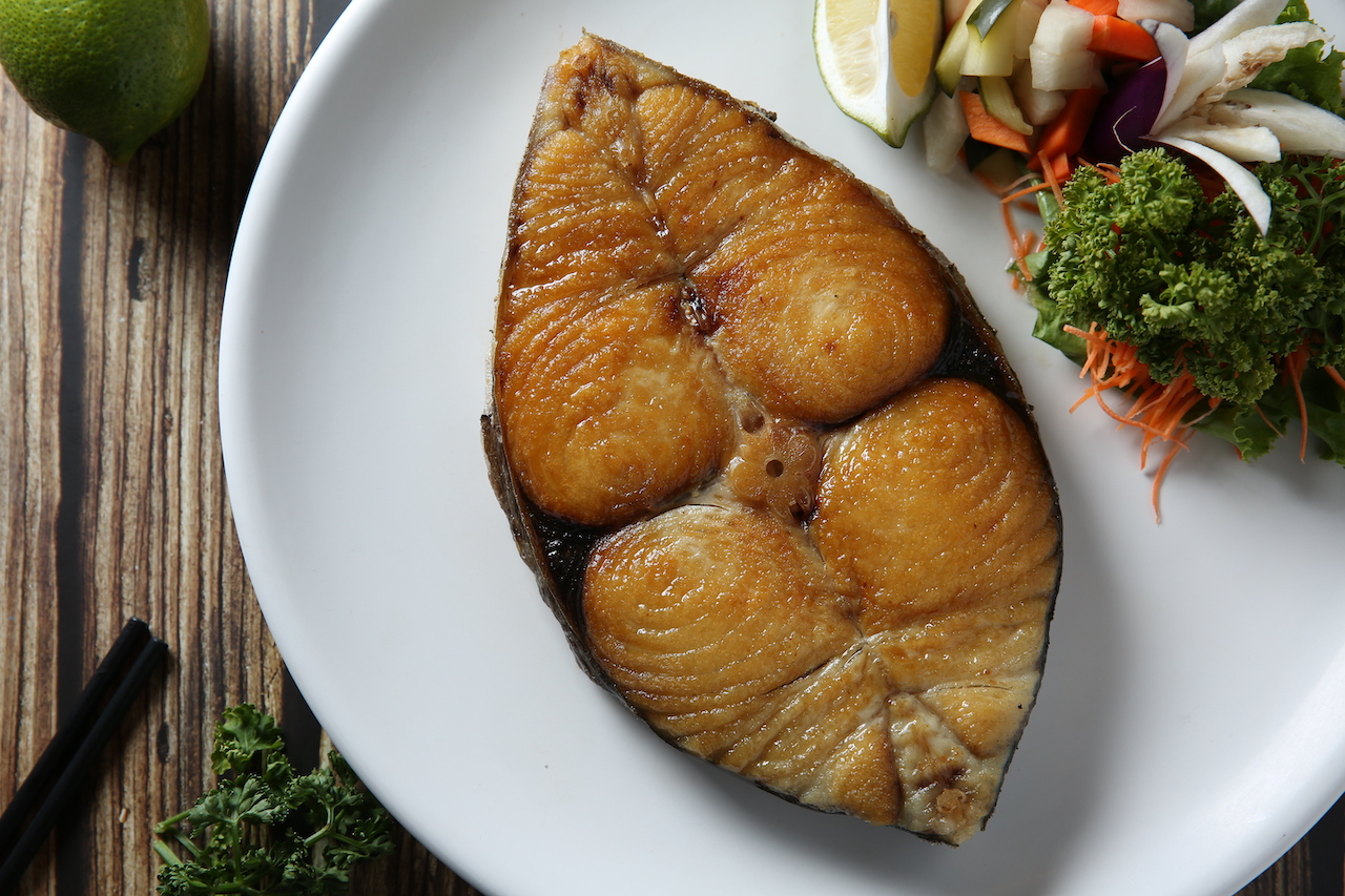 煎的金黃恰恰的「澎湖𩵚魠魚」，魚肉保有香潤的魚汁。（時價，圖中為1,200元／塊）