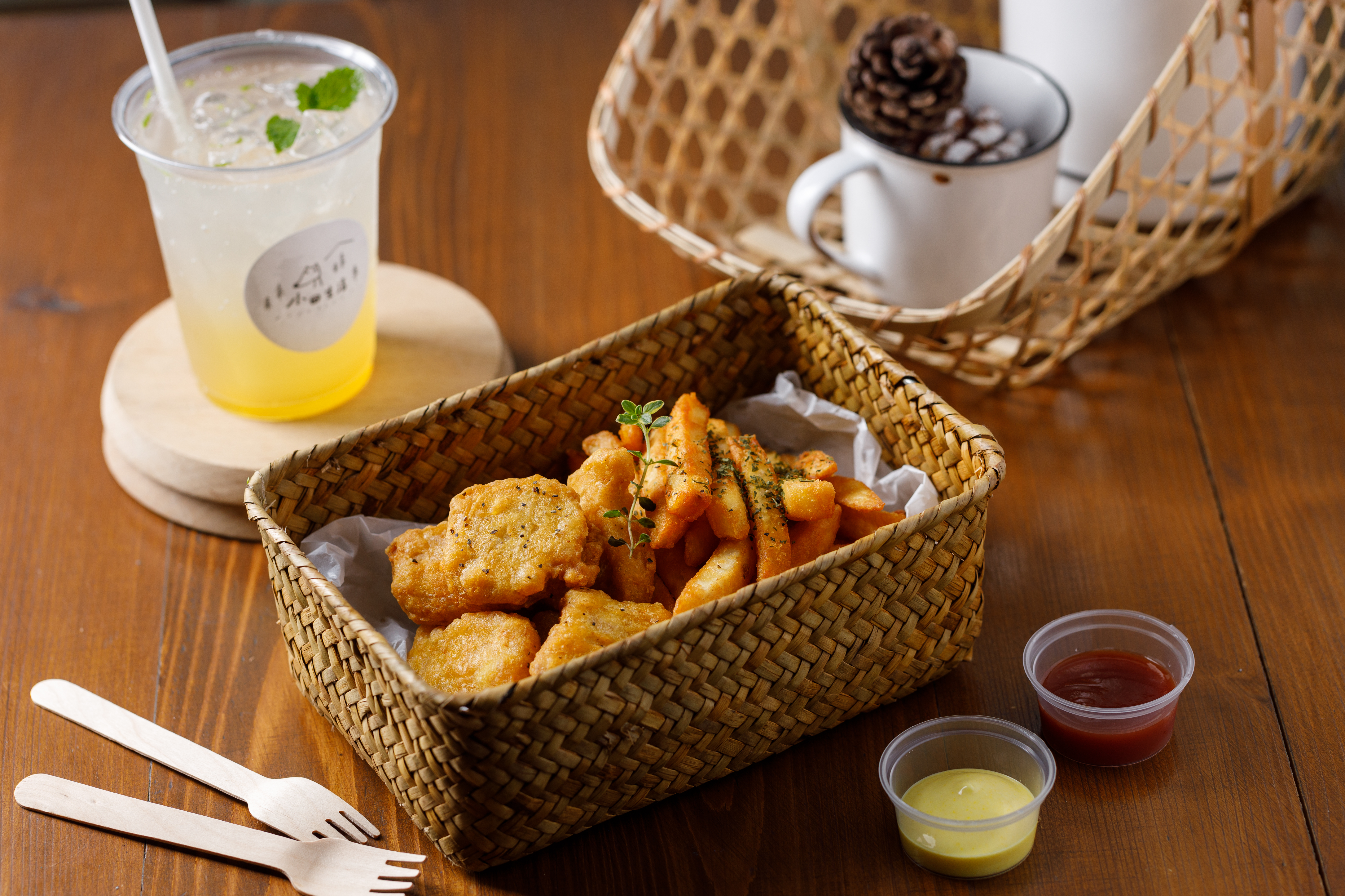 店內提供簡單鹹食「蜂蜜芥末/原味脆薯」(右前,90元/份)、「好吃黃金雞塊」(左前,90元/份),與「百花蜜檸檬氣泡水」(後,135元/杯)。