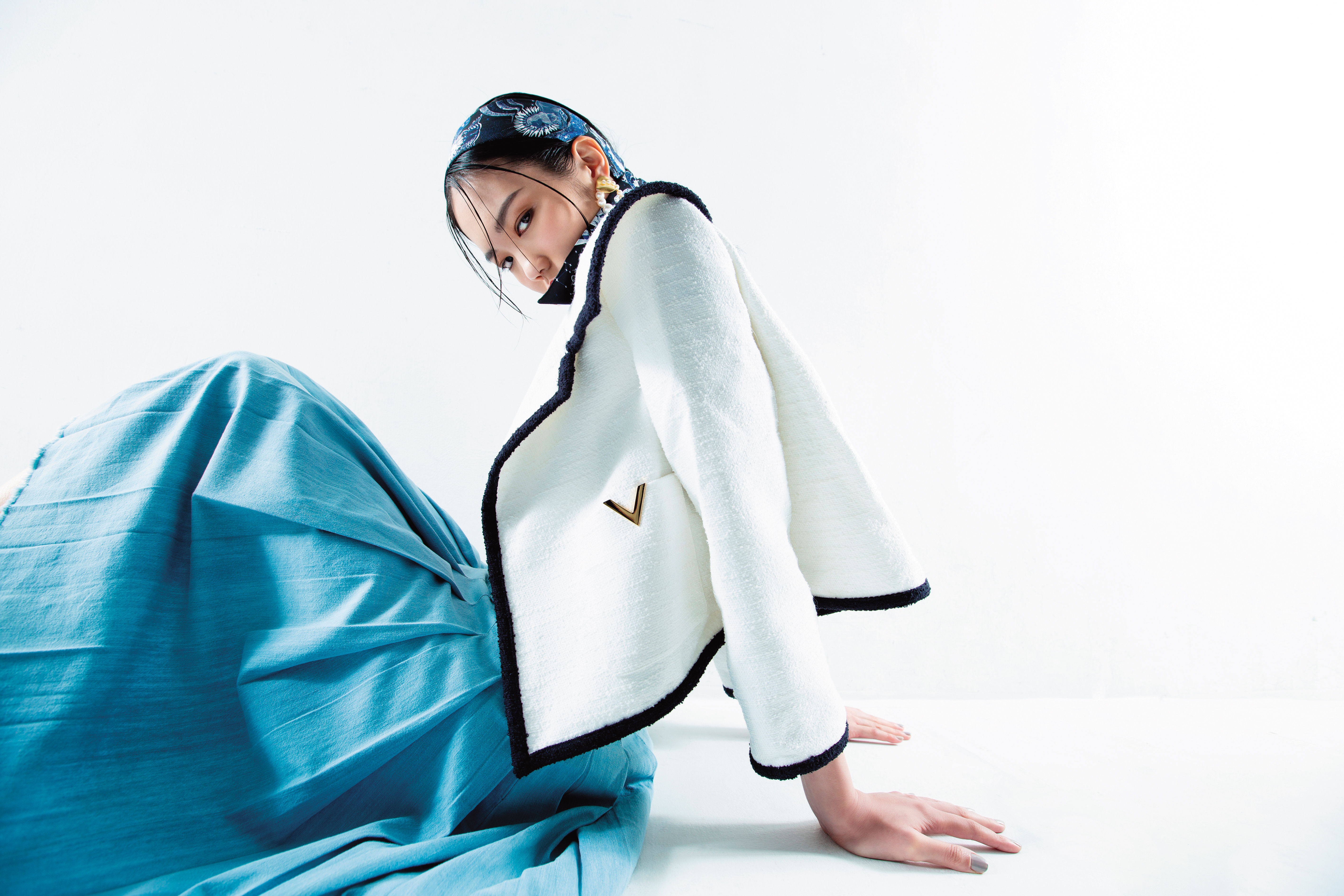 粗呢大翻領短外套NT$146,000 by VALENTINO；針織上衣NT$43,600 by VALENTINO；丹寧百褶裙NT$47,000 by MIU MIU；Mitzah Dior Zodiac Fantastico海軍藍絲巾NT$8,200 by DIOR；金色海貝珍珠耳環NT$7,680 by OYJ。