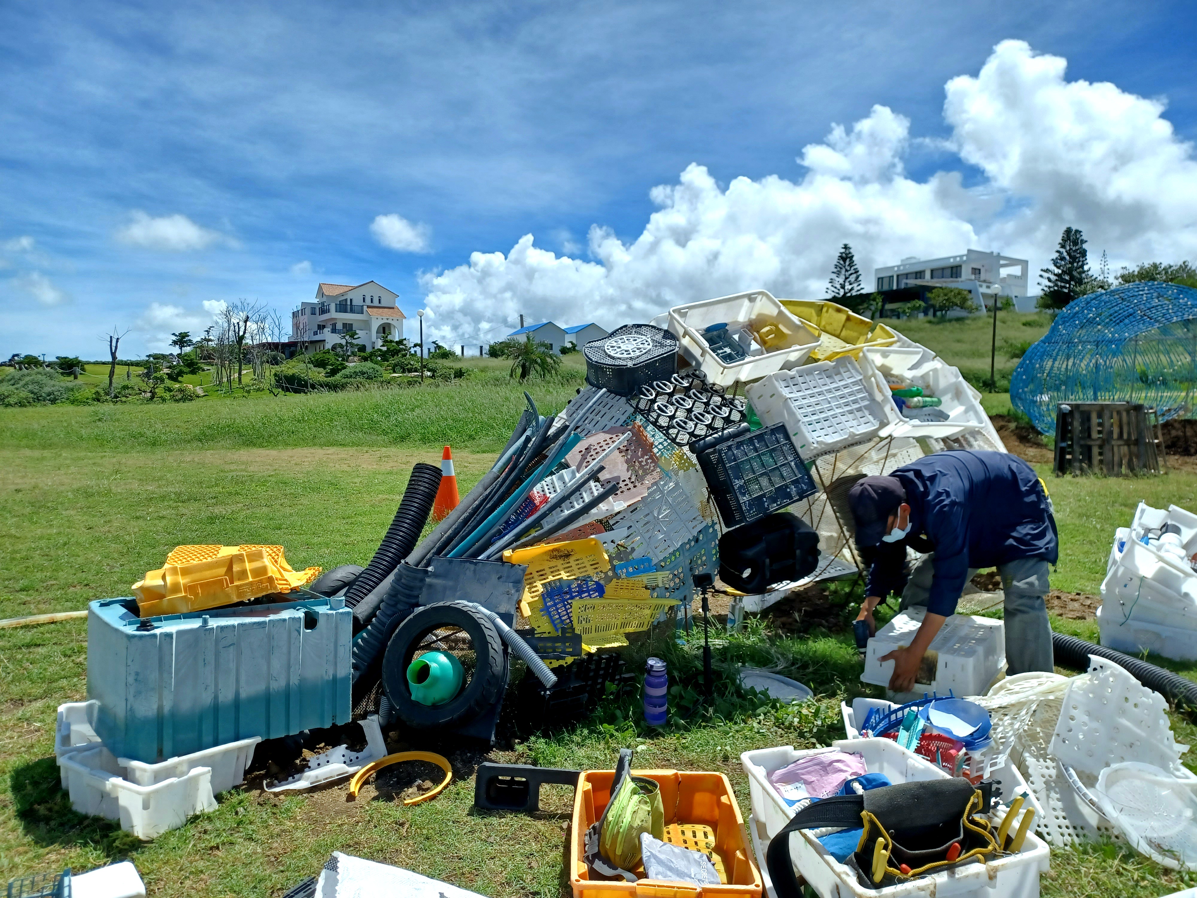 海漂實驗室團隊的藝術家戴碩毅和海漂藝工隊的作品《海盒機械獸》，是由海廢塑膠籃筐、浮球、各式海廢塑膠垃圾所組成。（唐采伶提供）