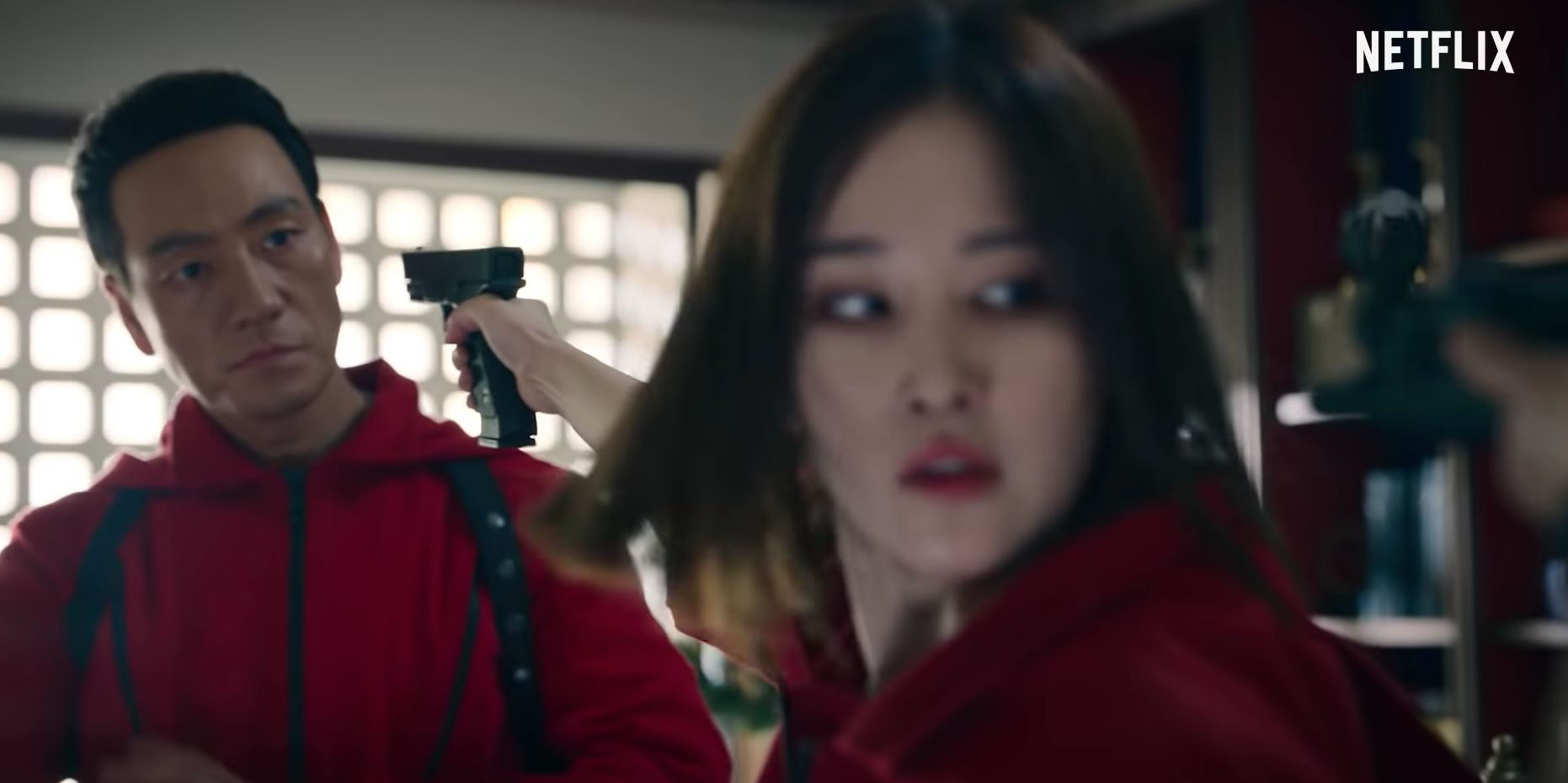 全鍾瑞(右)拿槍對著朴海秀,自己也被槍指著頭。(截圖自Netflix)