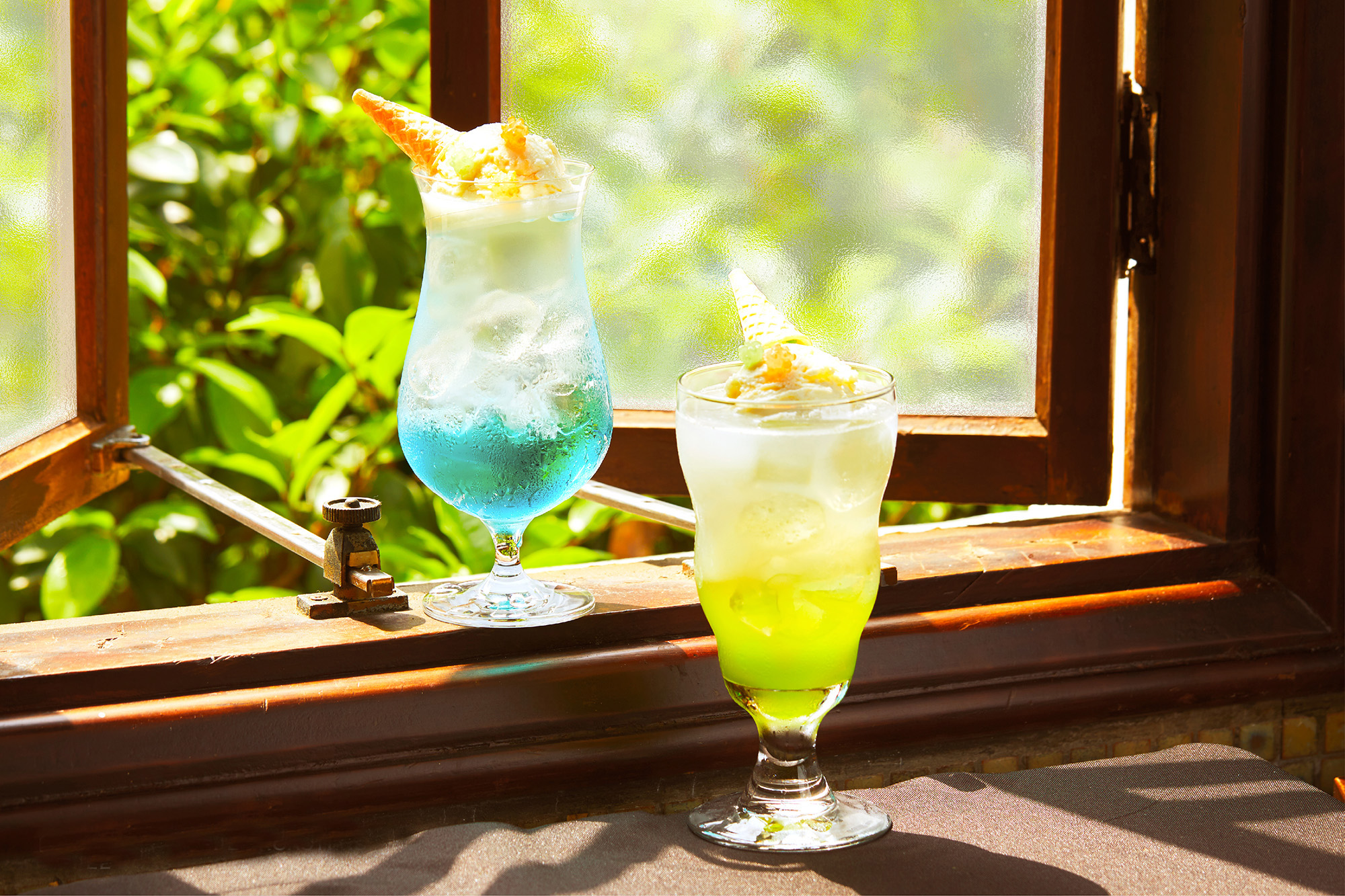 黃澄亮眼的「青蘋果風味冰淇淋蘇打」（右）以糖果妝點，帶出童稚感。（180元／杯，豆留森林提供）