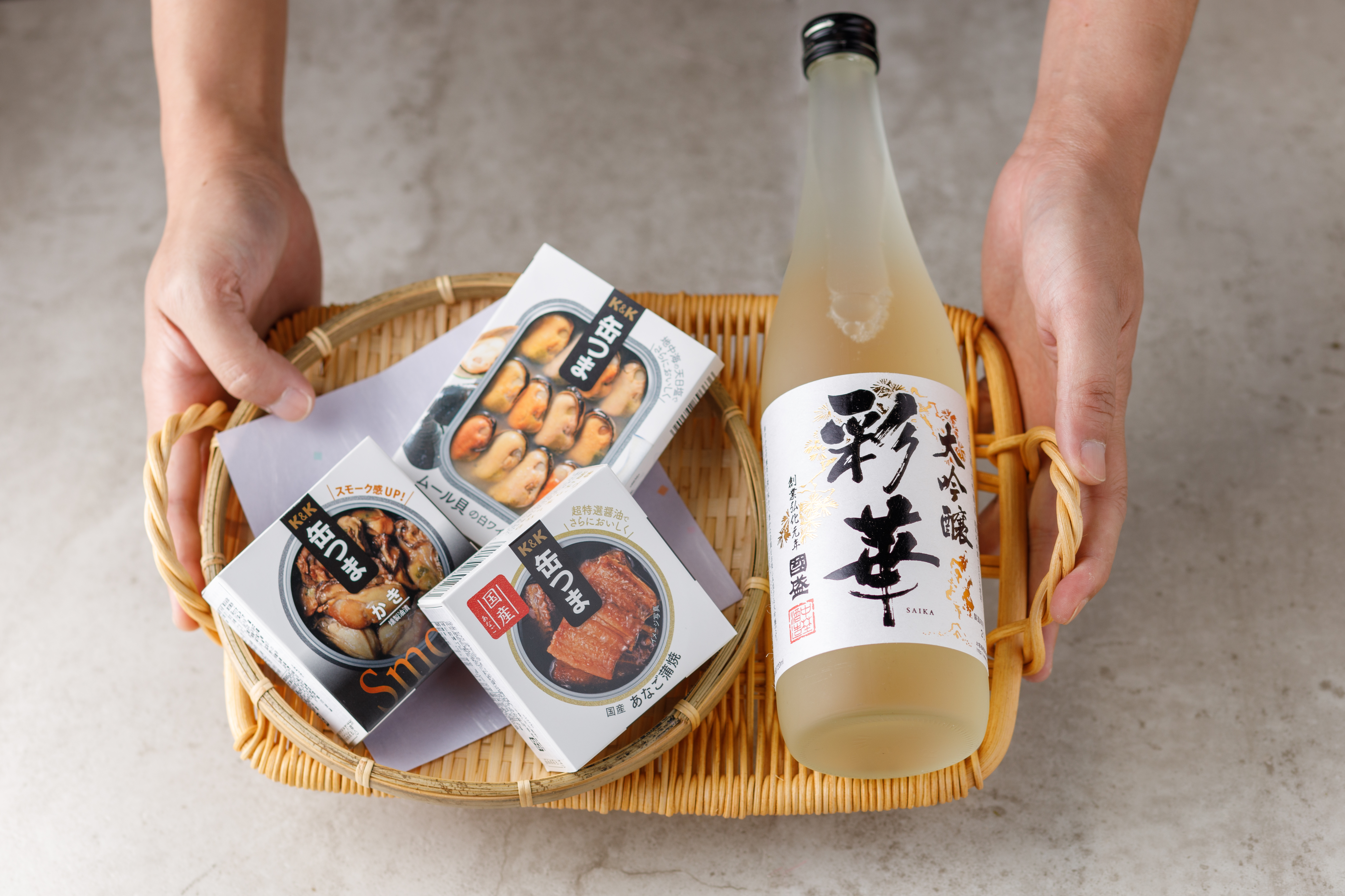 「特撰國盛彩華大吟釀」（右，780元／瓶）搭配「K&K罐頭系列」（左，225～280元／罐），有種日式Tapas的時髦感。