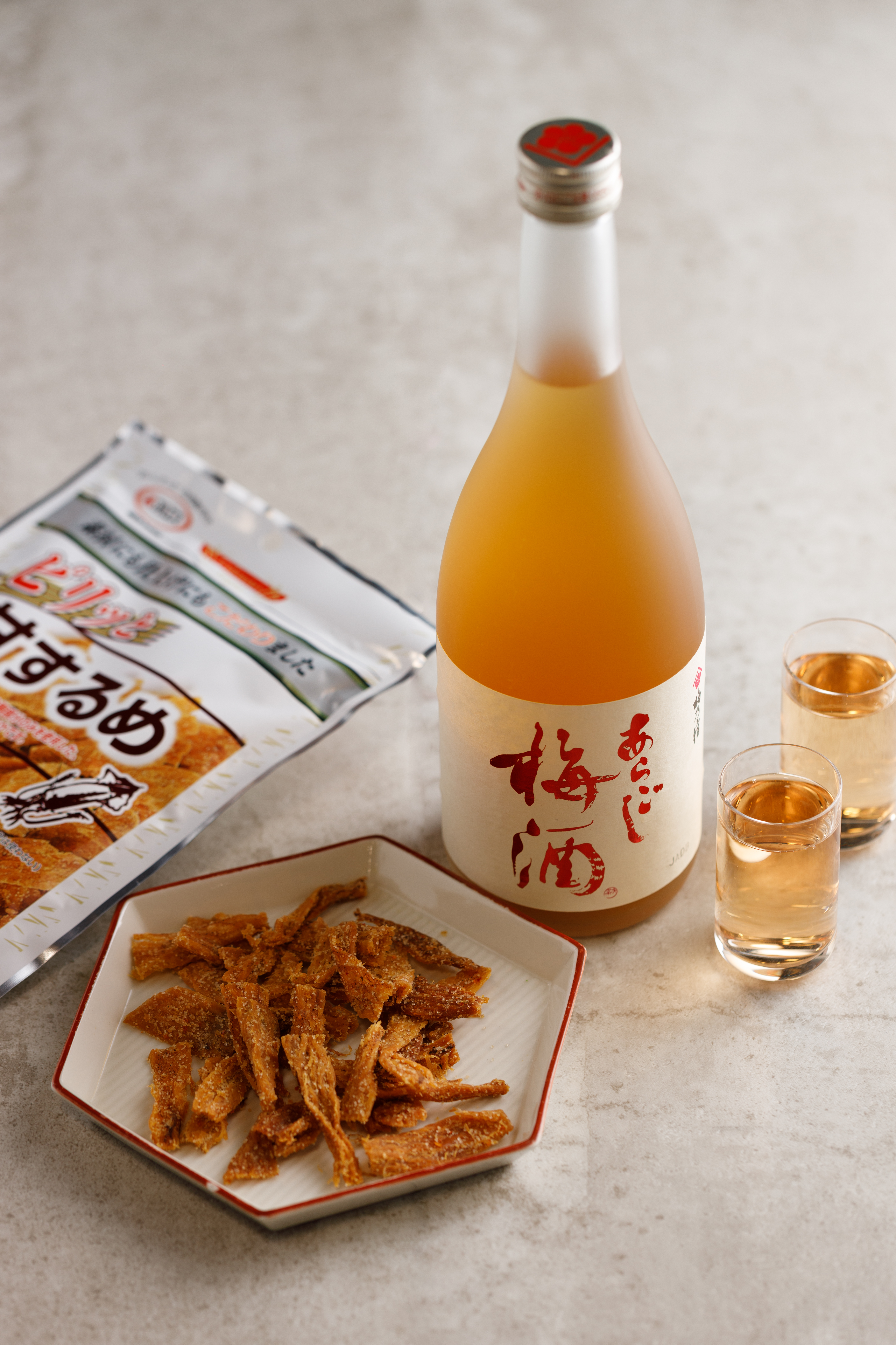 靜岡來的「花之舞 吟釀」（左，750元／瓶）喉韻清爽，帶有清甜果香與吟釀香，能撫慰被「辣味帆立貝」（右，490元／包）震撼的舌尖。