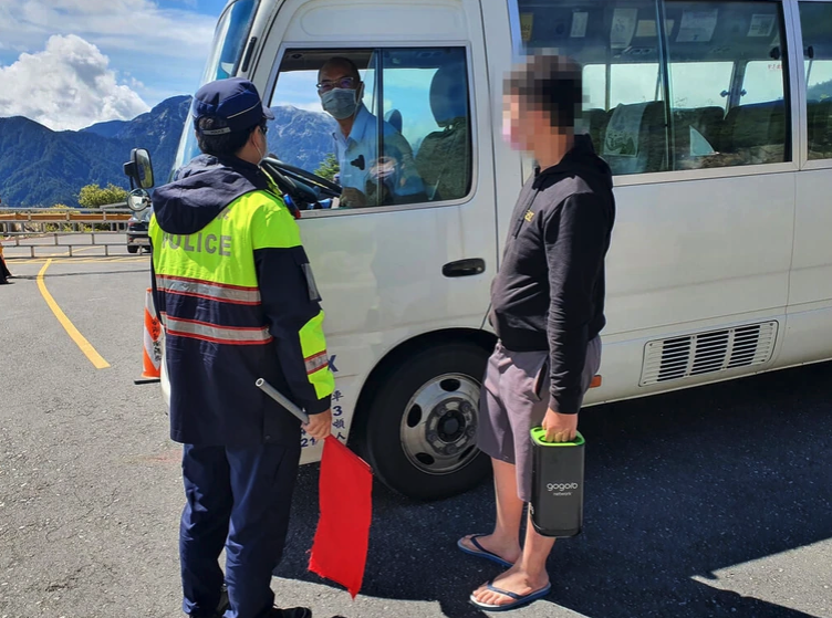 員警林奕福送騎士至接駁站轉乘小巴,前往36公里外的清境換電池。(新城分局提供)