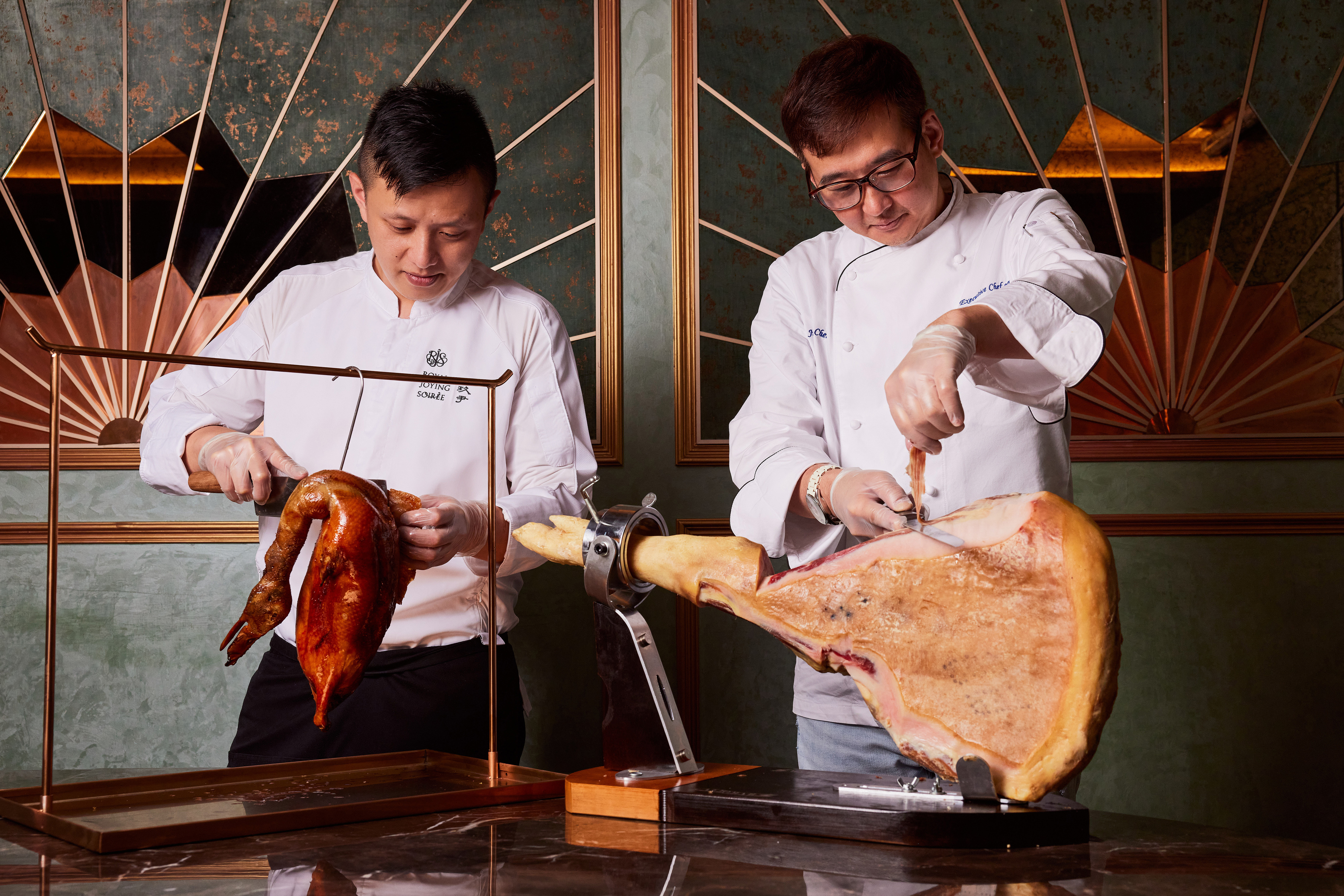 限定餐會上，「玖尹」行政總主廚陳溫仁Jimmy（右）與廚藝總監李冠儀（左）以片鴨、火腿秀掀開序幕。（玖尹提供）