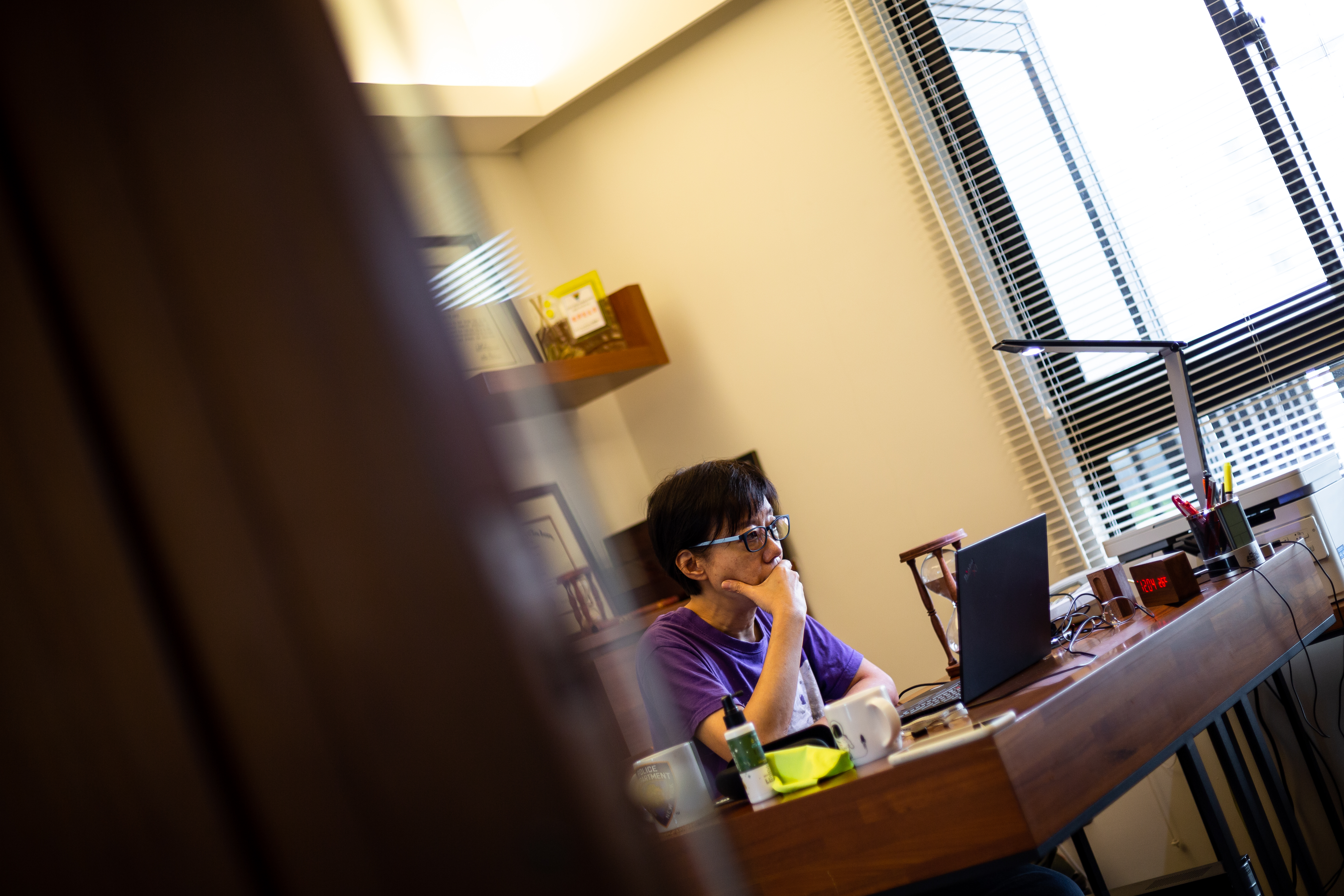 陳永儀專注在工作上，身旁的沙漏提醒著她時間。