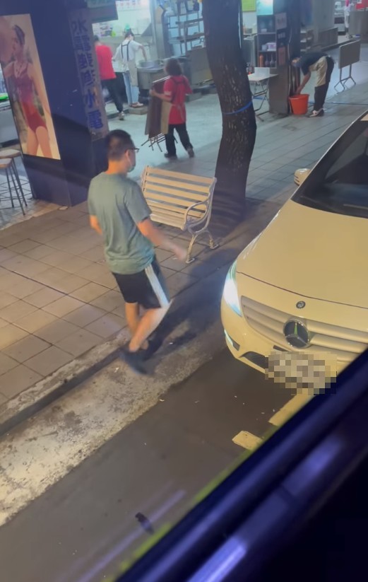 賓士車主嗆聲完後,又大搖大擺往店家方向前去。(翻攝爆料公社)