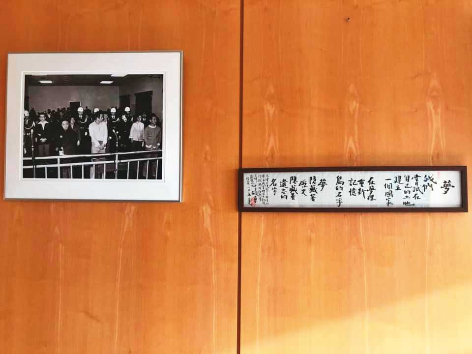 謝志偉辦公室牆上掛著美麗島大審的黑白照，一邊掛著他從台灣帶來的李敏勇詩作。