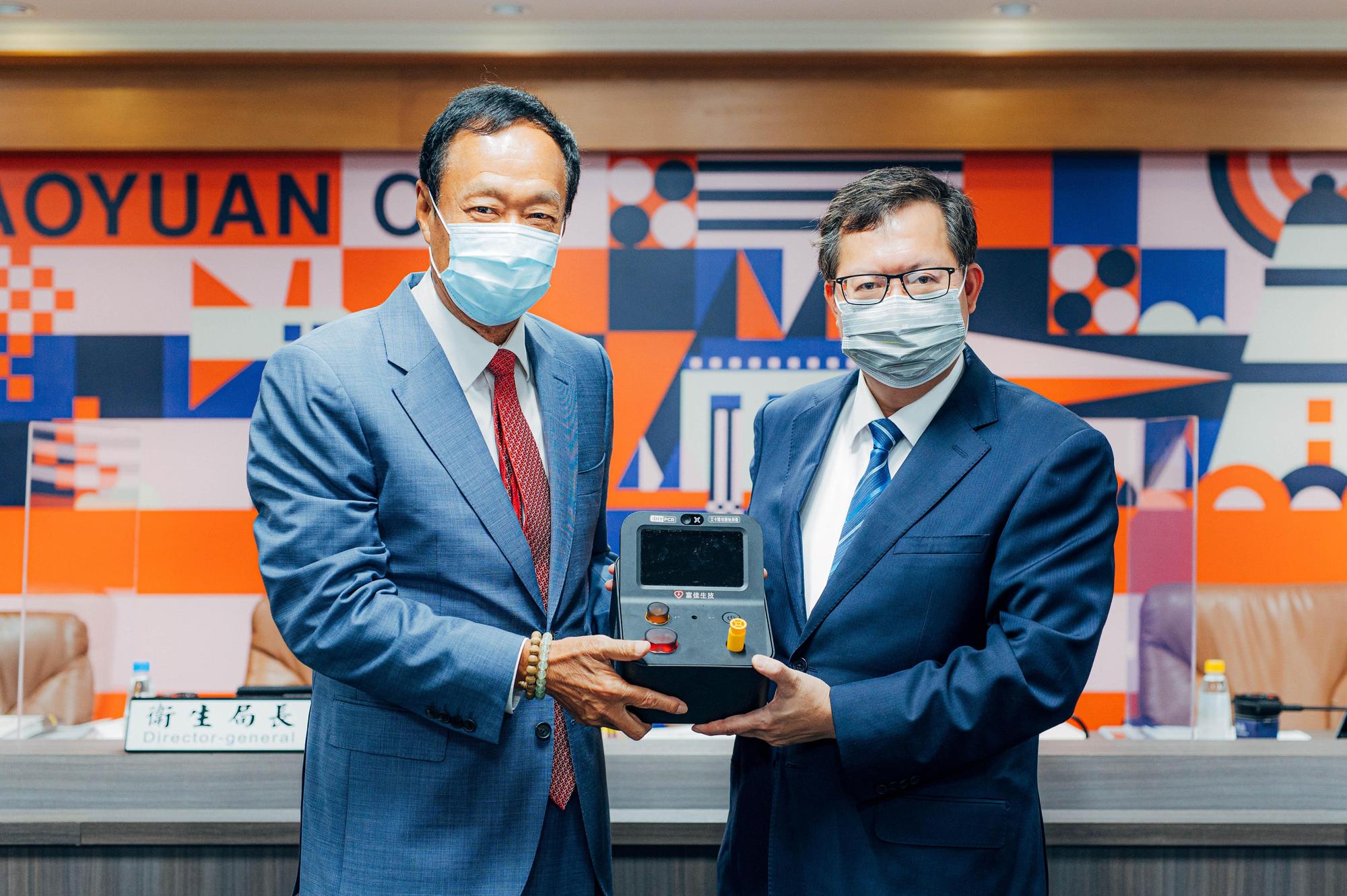 鄭文燦代表桃園市府接受郭台銘捐贈的家用PCR檢測儀。(桃園市政府提供)