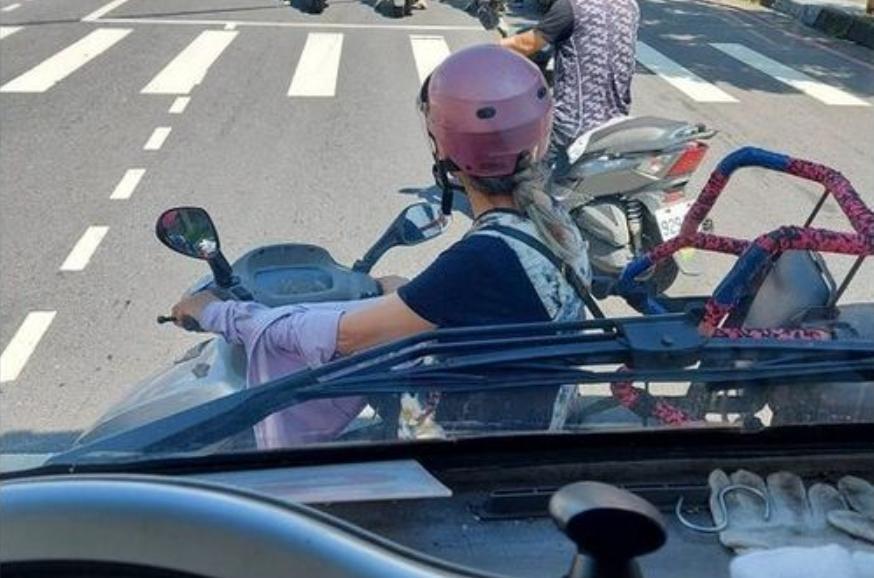 男網友po出照片，指出有一名女子騎車停在他的車頭前躲太陽，然而網友卻發現另有隱情。（翻攝自爆料公社二社）