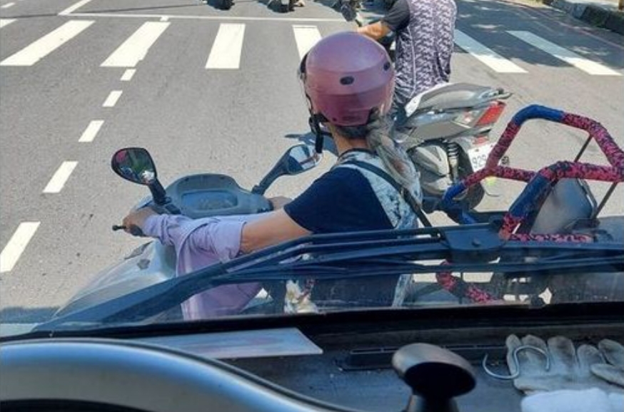 男網友po出照片，指出有一名女子騎車停在他的車頭前躲太陽，然而網友卻發現另有隱情。（翻攝自爆料公社二社）