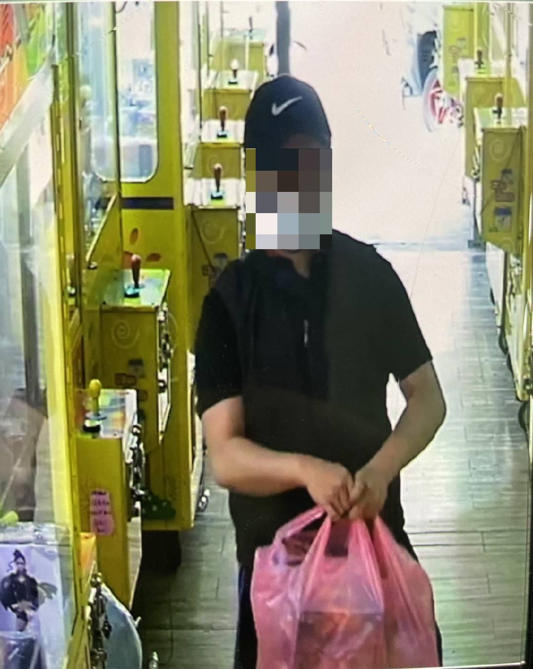 熊嫌將公仔贓物放進塑膠袋中。（警方提供）