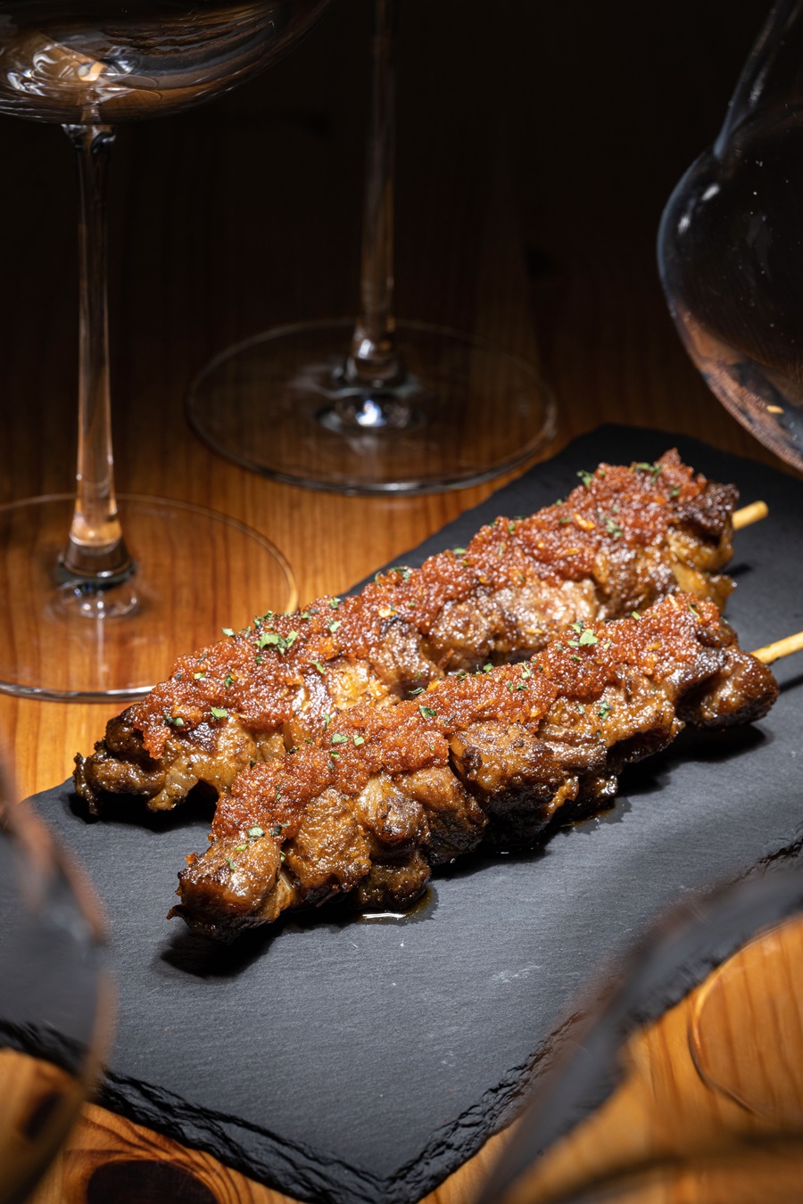 「摩爾伊比利豬肋條串佐MOJO醬」肉串以孜然、香草醃製，塗上沙沙的MOJO醬，味道豪邁。（220元／份）