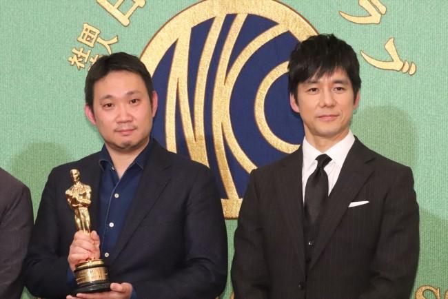 濱口竜介導演(左)和《在車上》男主角西島秀俊從奧斯卡頒獎典禮返回日本後,與日本媒體分享獲獎喜悅。(翻攝自crankin)