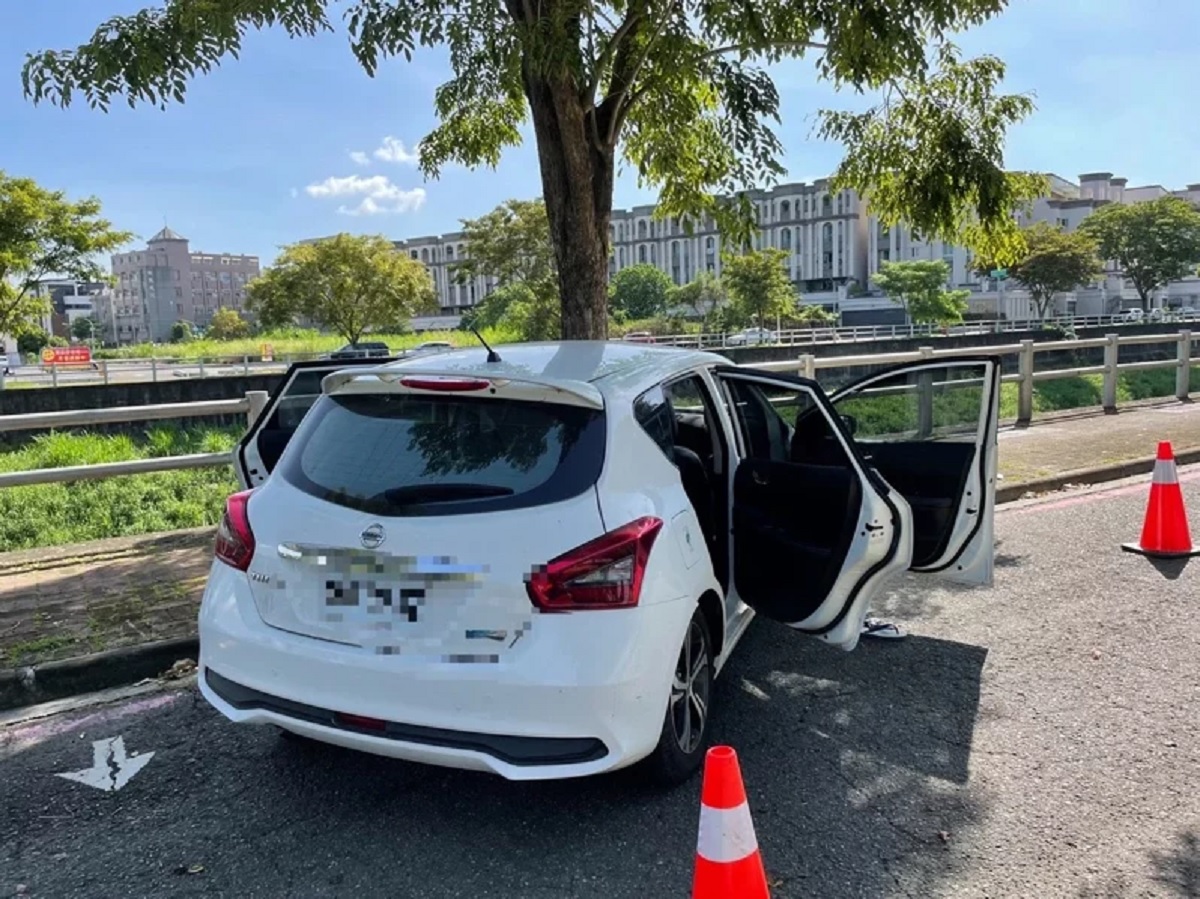 楠梓發生離奇車禍，白色轎車自撞路樹後留在原地，只留下車上的20多顆子彈及彈殼。（翻攝畫面）
