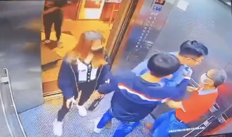 胡男（藍衣）認為老翁（紅衣）是故意關電梯門才會夾到他，上前氣憤理論。（翻攝爆廢公社）