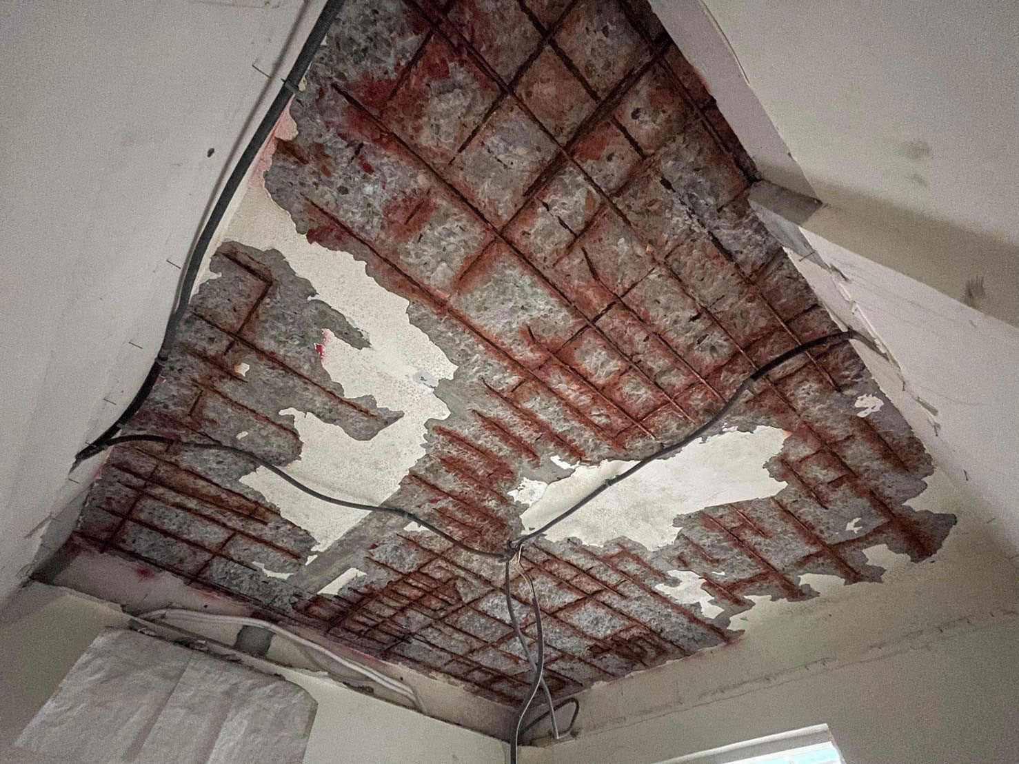 陳先生花了大錢買屋，裝修時打開天花板，驚見大片鋼筋外露。（讀者提供）