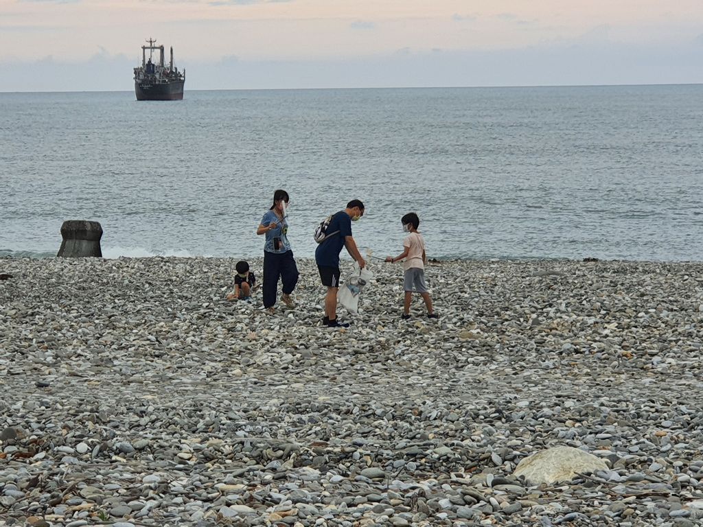 一對父母帶著小孩前往花蓮海岸遊玩時,一家人沿海岸線撿拾垃圾。(翻攝自花蓮人臉書)