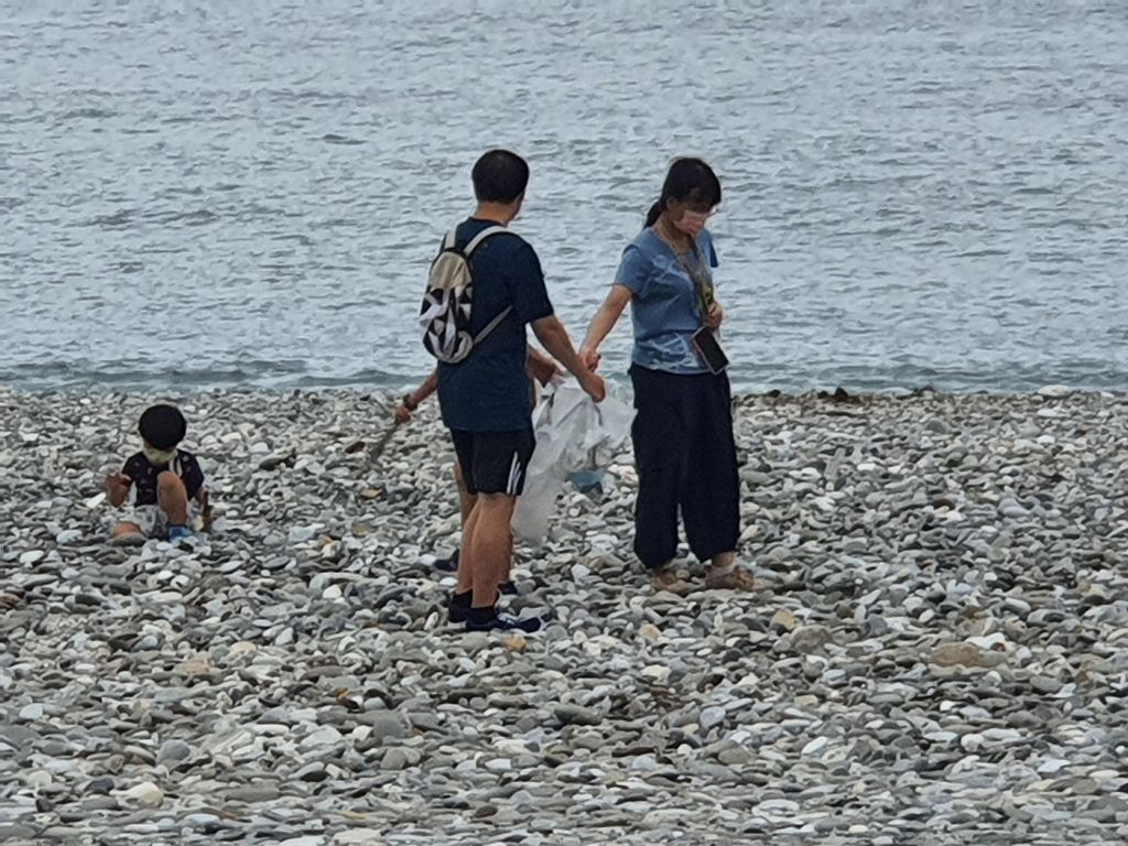 一對父母帶著小孩前往花蓮海岸遊玩時，一家人沿海岸線撿拾垃圾。（翻攝自花蓮人臉書）