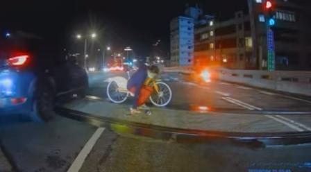 一名老婦人在車流龐大的百齡橋上打算橫跨，甚至還滑倒，畫面險象環生。（翻攝自報廢公社二館臉書社團）