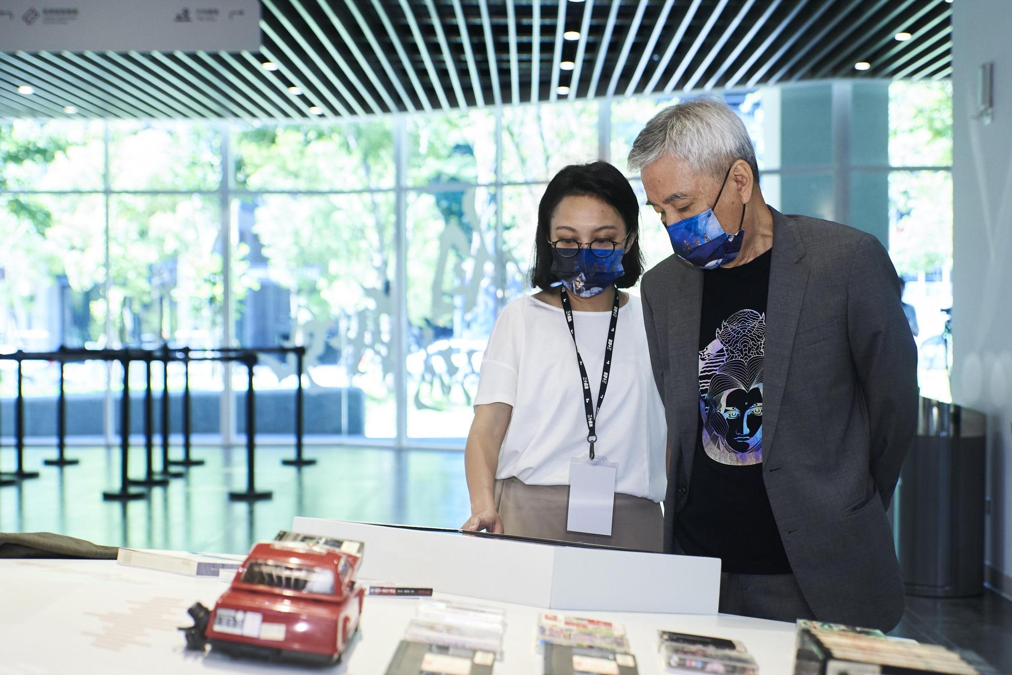 黃文章與女兒看著紀念展收藏,憶起與弟弟黃文擇小時候的生活點滴。(霹靂國際多媒體提供)