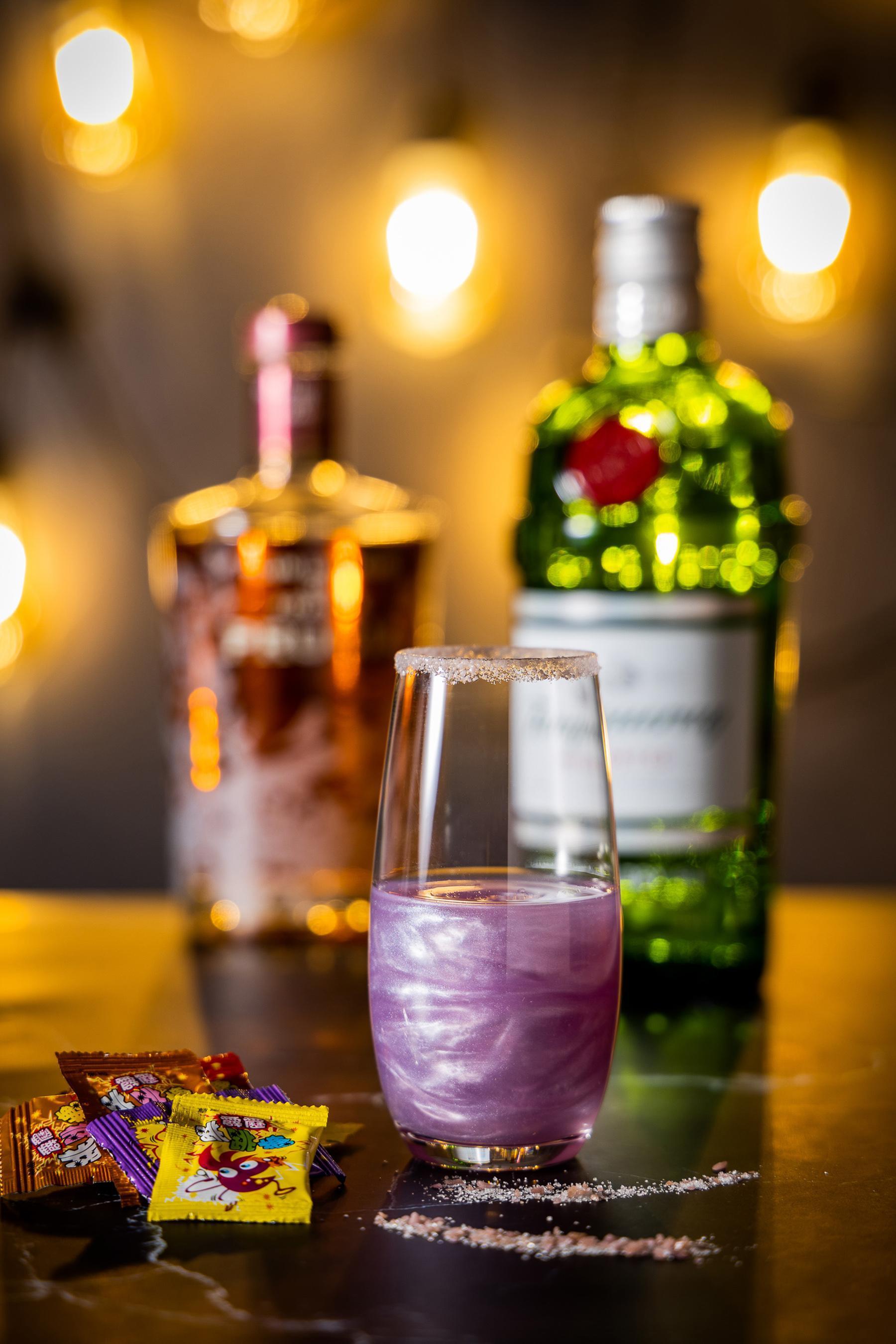 「星空漩渦」使用酒吧自製的蝶豆花琴酒,在杯緣抹上一圈跳跳糖,酸甜蜜李口味星空酒與跳跳糖在舌頭上跳舞,交織出一場雙人節奏曼妙舞曲。(大直英迪格酒店提供)