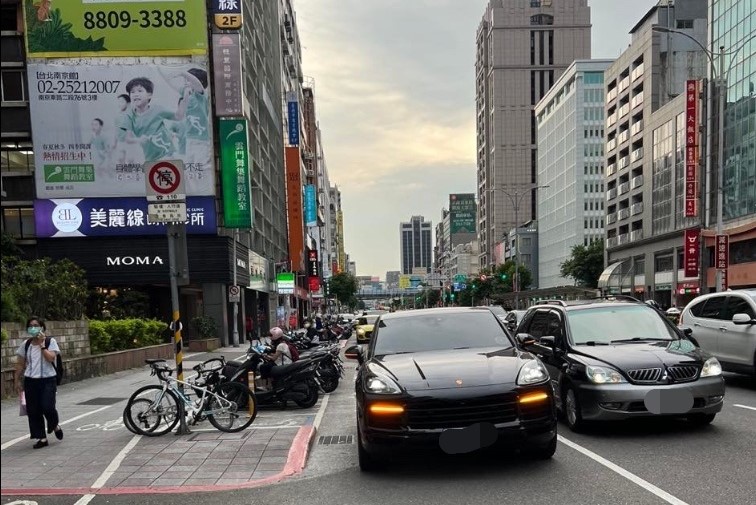 男網友遇上一輛保時捷違停，駕駛突開車門讓他反應不及差點撞上。（翻攝自爆料公社二社） 