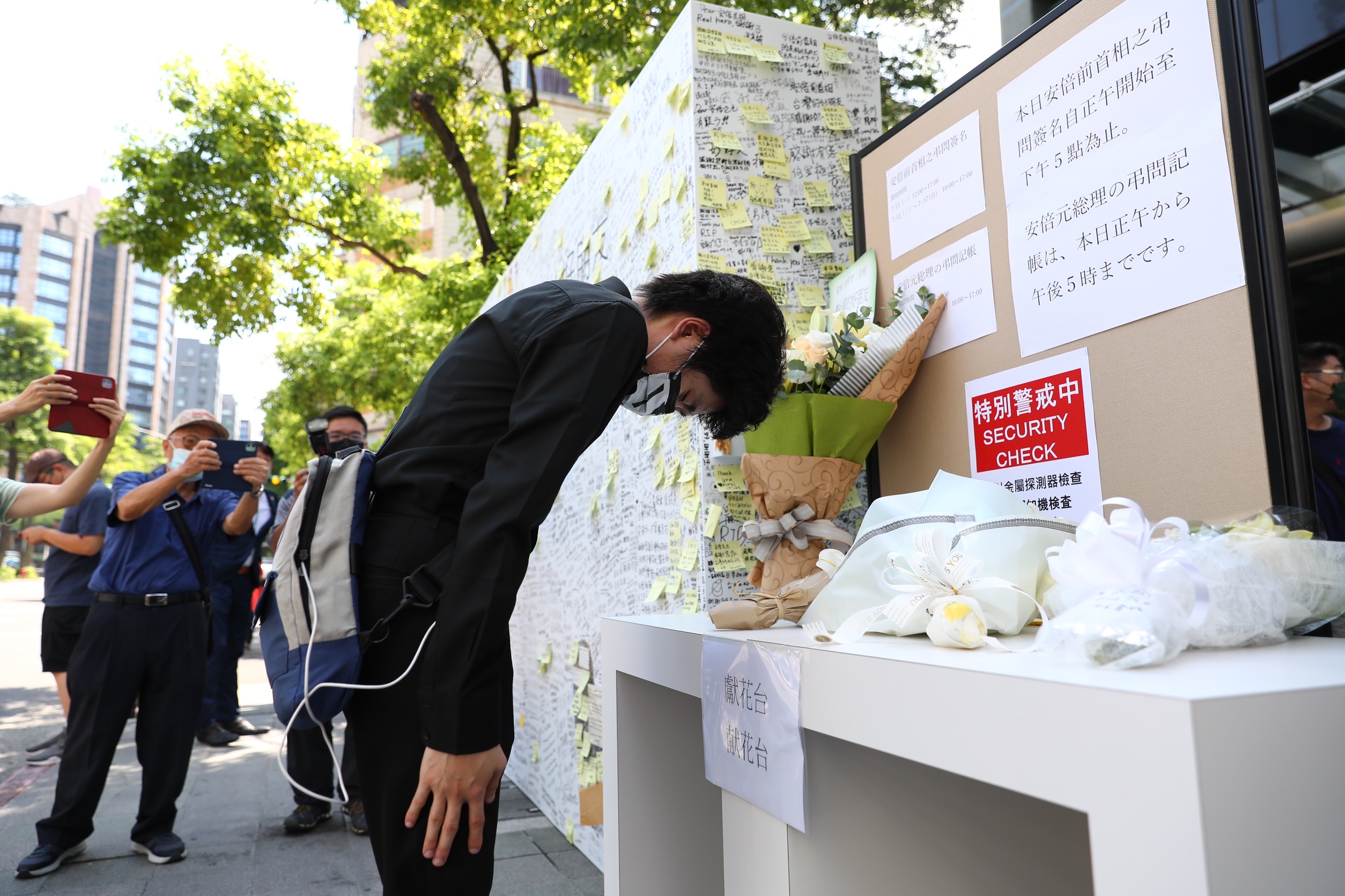 民眾前往日本台灣交流協會,對著安倍晉三的追思牆鞠躬,也有民眾前來獻花。