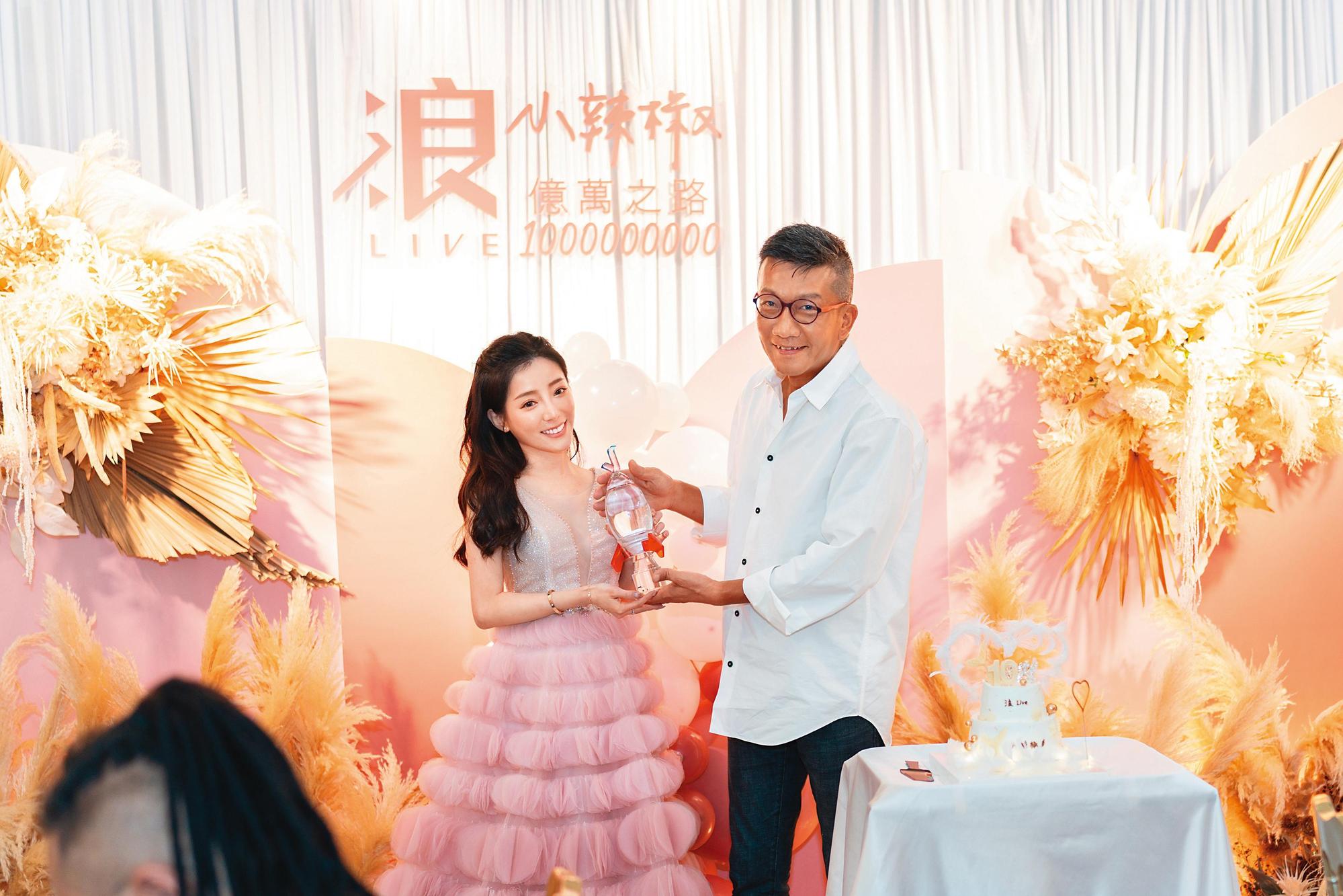 小辣椒(左)成為台灣首位破億收入直播主,浪LIVE除了為她舉辦感恩餐會,董事長王冠中(右)也特地頒發獎座。(浪LIVE提供)